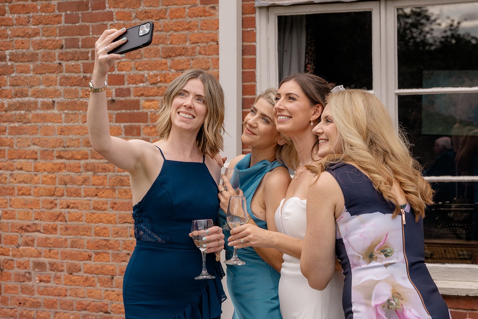 Wedding guests taking a selfie during the drinks reception at Broadfield Court in Herefordshire, photographed by Just James Weddings for fun candid wedding moments.