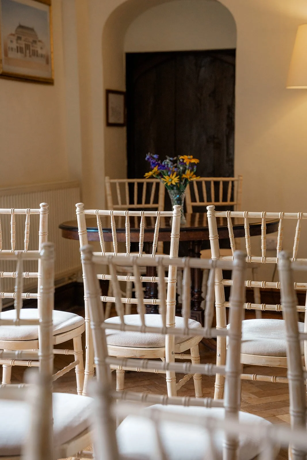 Close view of the indoor ceremony setup at Broadfield Court in Herefordshire, with white chairs and simple floral styling, photographed by Just James Weddings for venue inspiration.