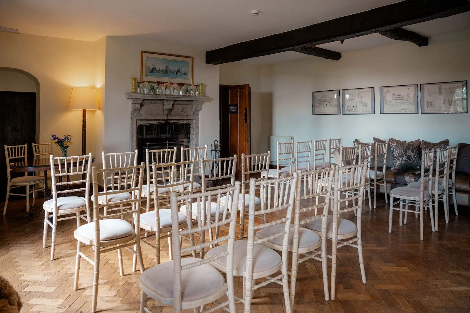 Wedding ceremony room at Broadfield Court in Herefordshire, with rows of white chairs, wooden beams and a stone fireplace, photographed by Just James Weddings for country house wedding inspiration.