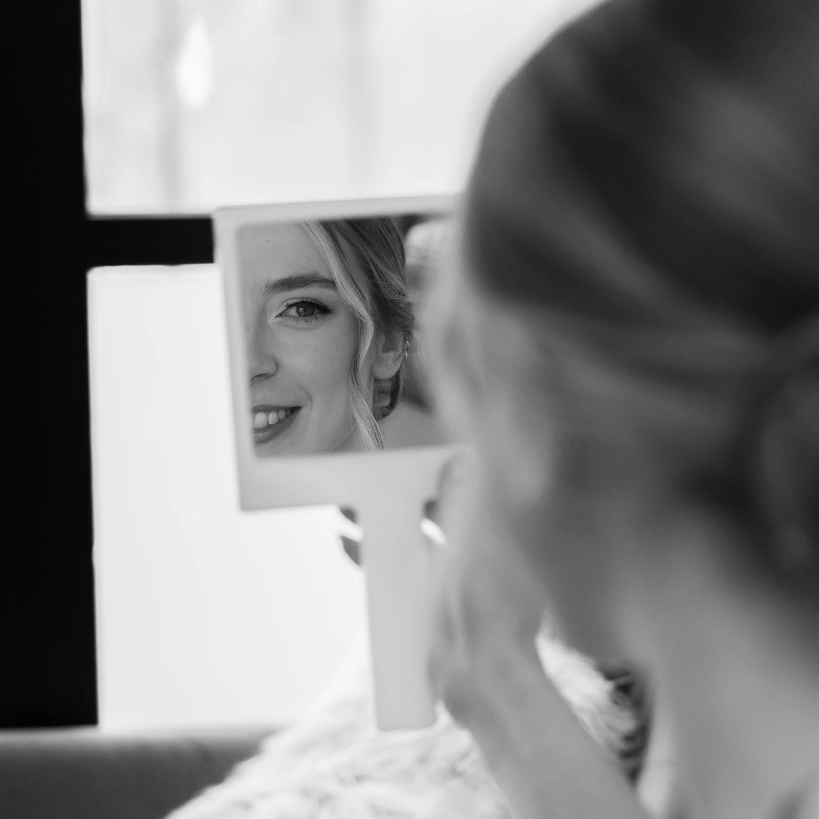 Black and white bridal prep detail of Josie reflected in a small mirror at Clifton Observatory in Somerset, photographed by Just James Weddings for natural wedding morning moments.