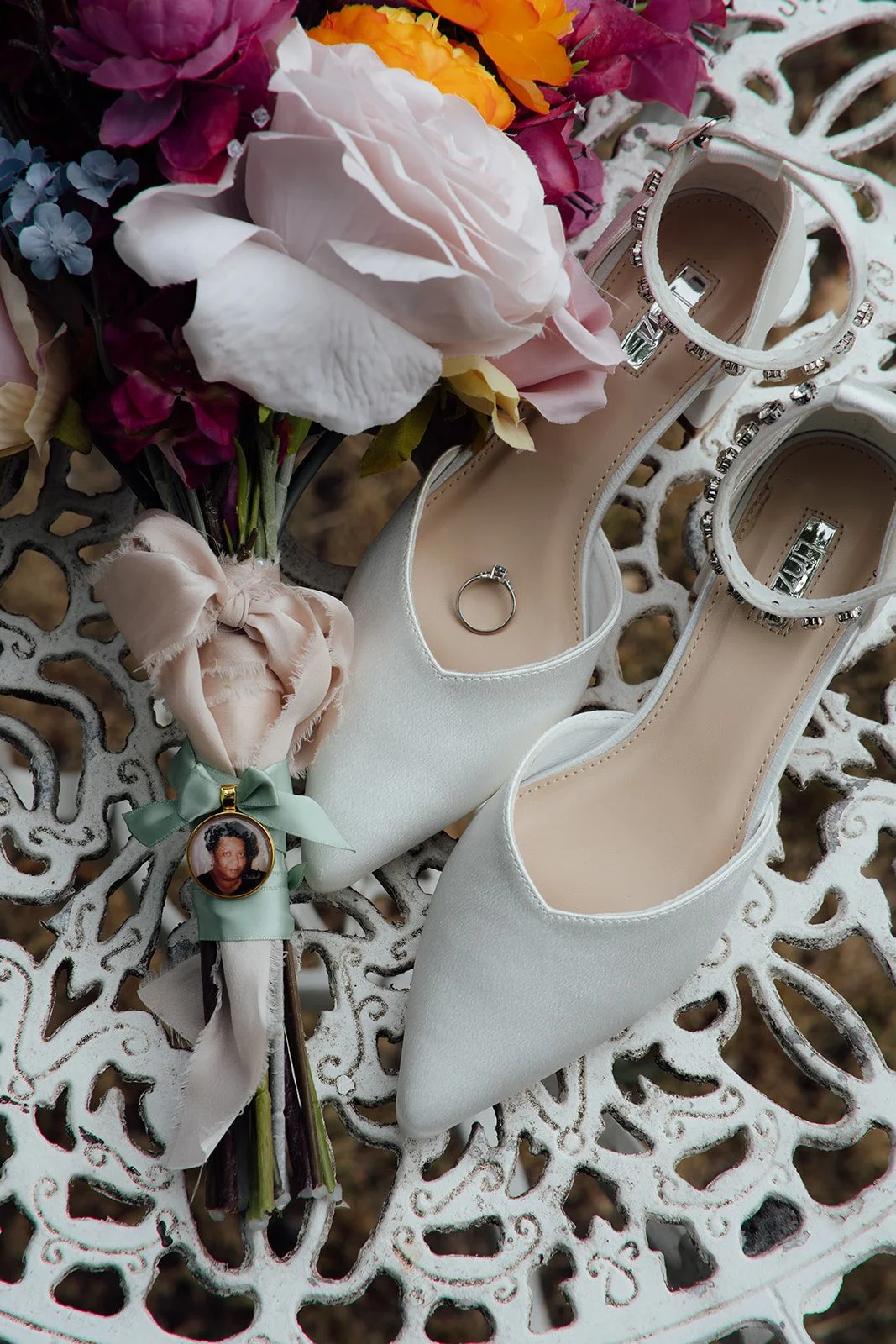 Kasey and Larisha’s colourful bridal bouquet, white wedding shoes and engagement ring arranged together at Oaks Farm Weddings in Surrey.