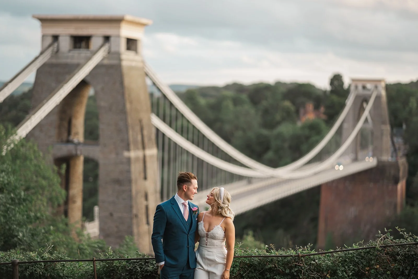 Kristy and Will pose together overlooking Clifton Suspension Bridge after their wedding at No. 4 Clifton Village in Bristol, UK, creating a scenic Bristol wedding portrait.