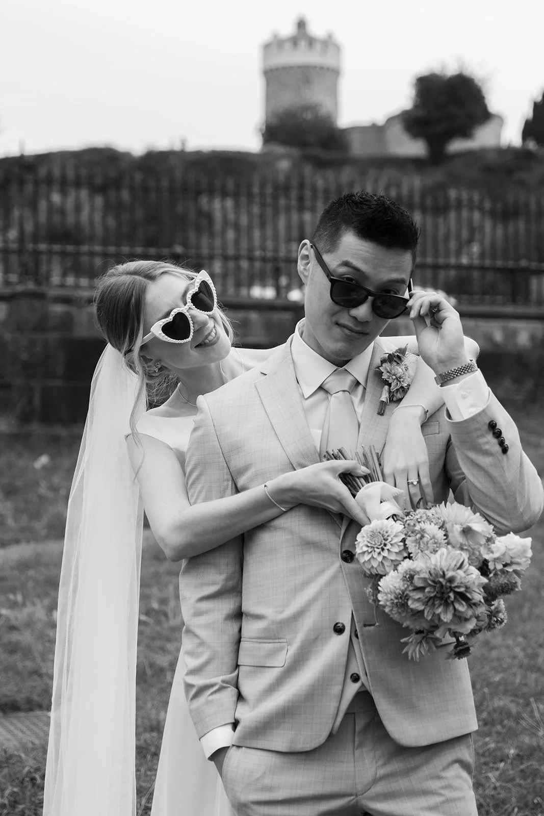 Black and white portrait of Brian & Josie showing their rings and bouquet at Clifton Observatory in Somerset, photographed by Just James Weddings in a fun documentary wedding style.