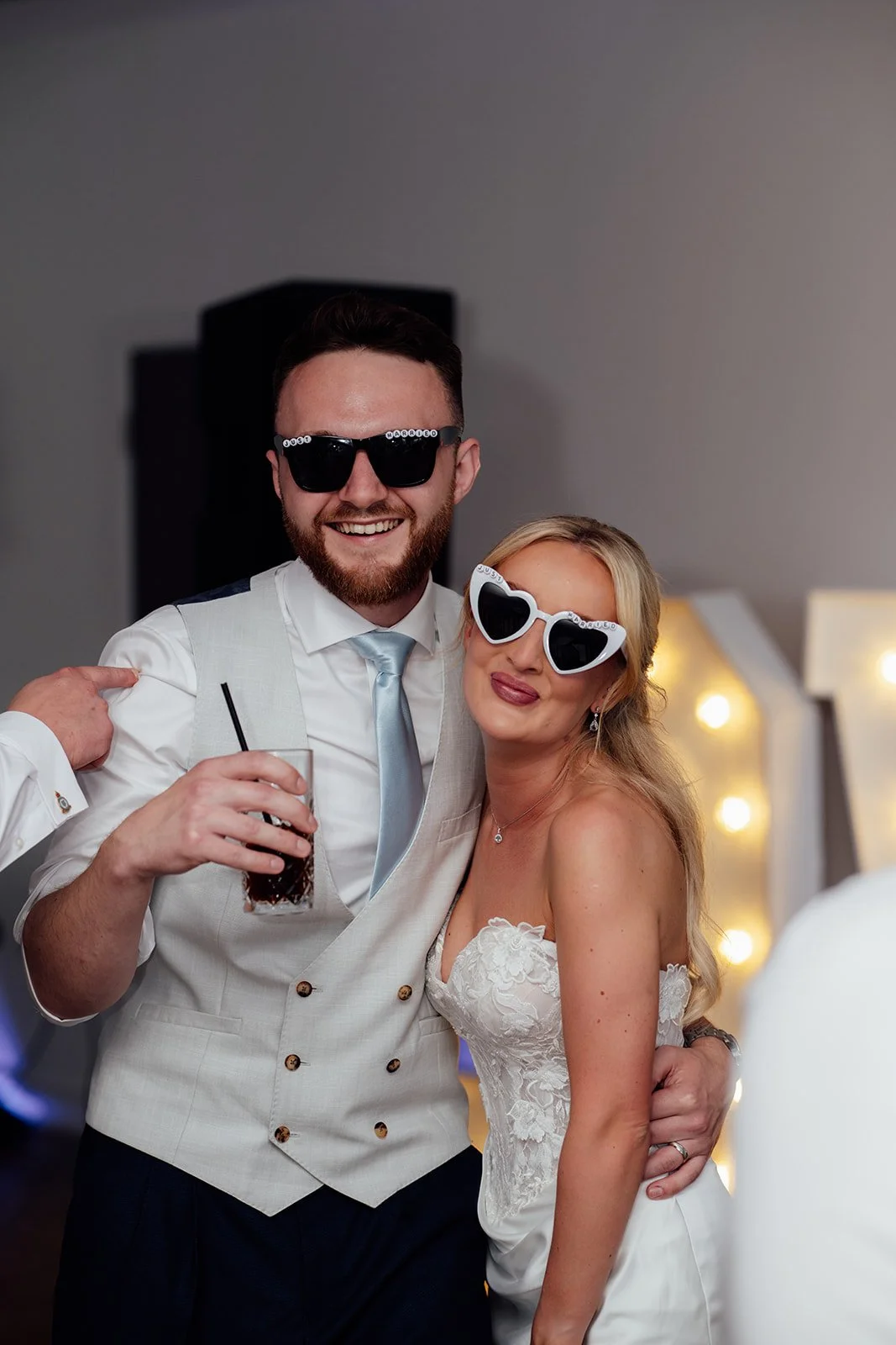 Amy & Connor smile together in playful wedding sunglasses during their evening reception at Sandy Cove Hotel in North Devon, UK.