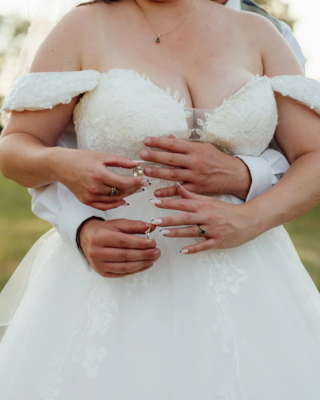 Close-up of Lucy and Matthew showing their wedding rings during their Somerset wedding at Curated Canvas at Noah’s Pond, photographed by Just James Weddings.