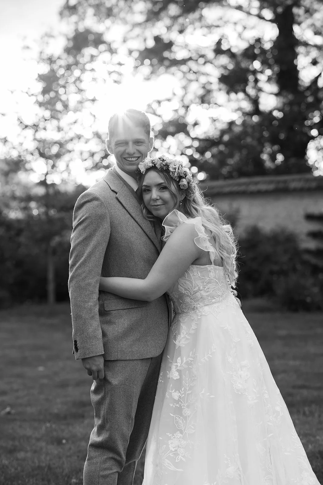 Black and white portrait of Jaye & Josh embracing outdoors at Syrencot in Wiltshire, photographed by Just James Weddings for romantic documentary wedding photography.
