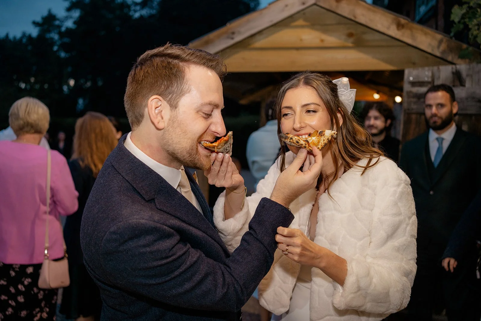 Lilly & Lloyd sharing pizza during their evening reception at Broadfield Court in Herefordshire, photographed by Just James Weddings for fun and candid wedding photography.