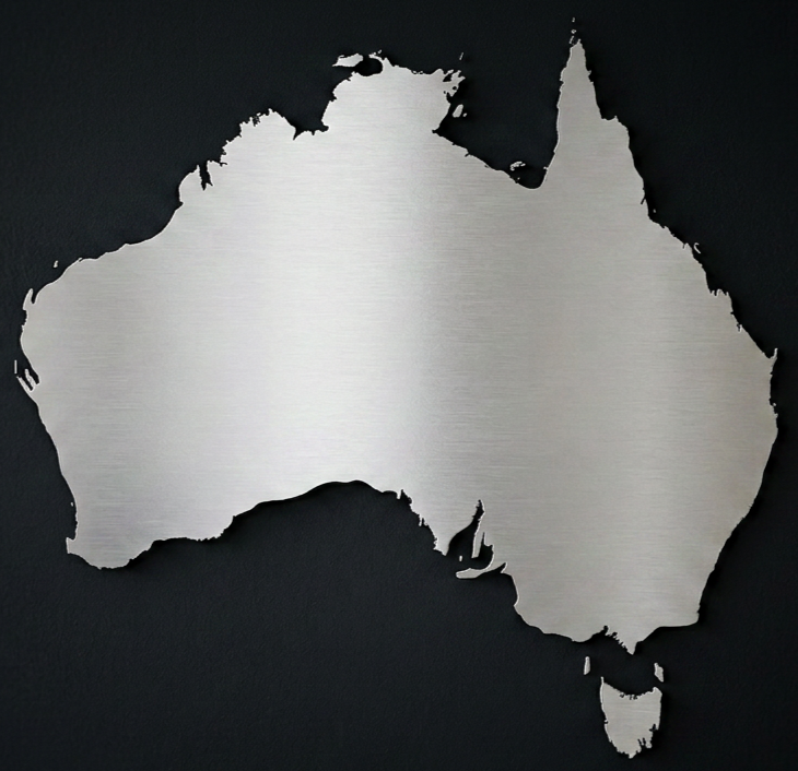 Silver metallic cutout of the map of Australia against a black background.