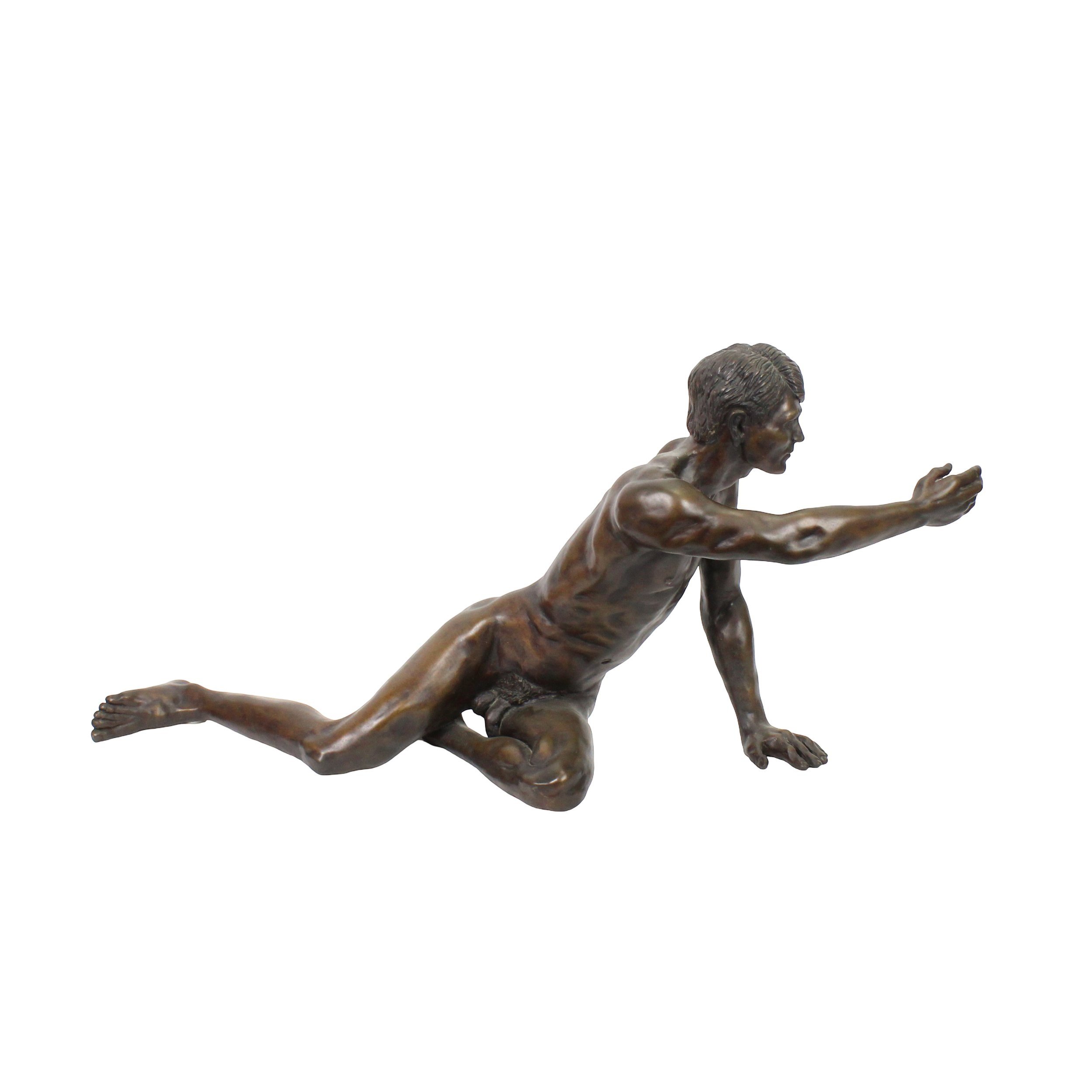 Bronze sculpture of nude man in a seated position reaching forward. His body is thin but muscular and his hair, in an ivy league cut, is highly detailed.
