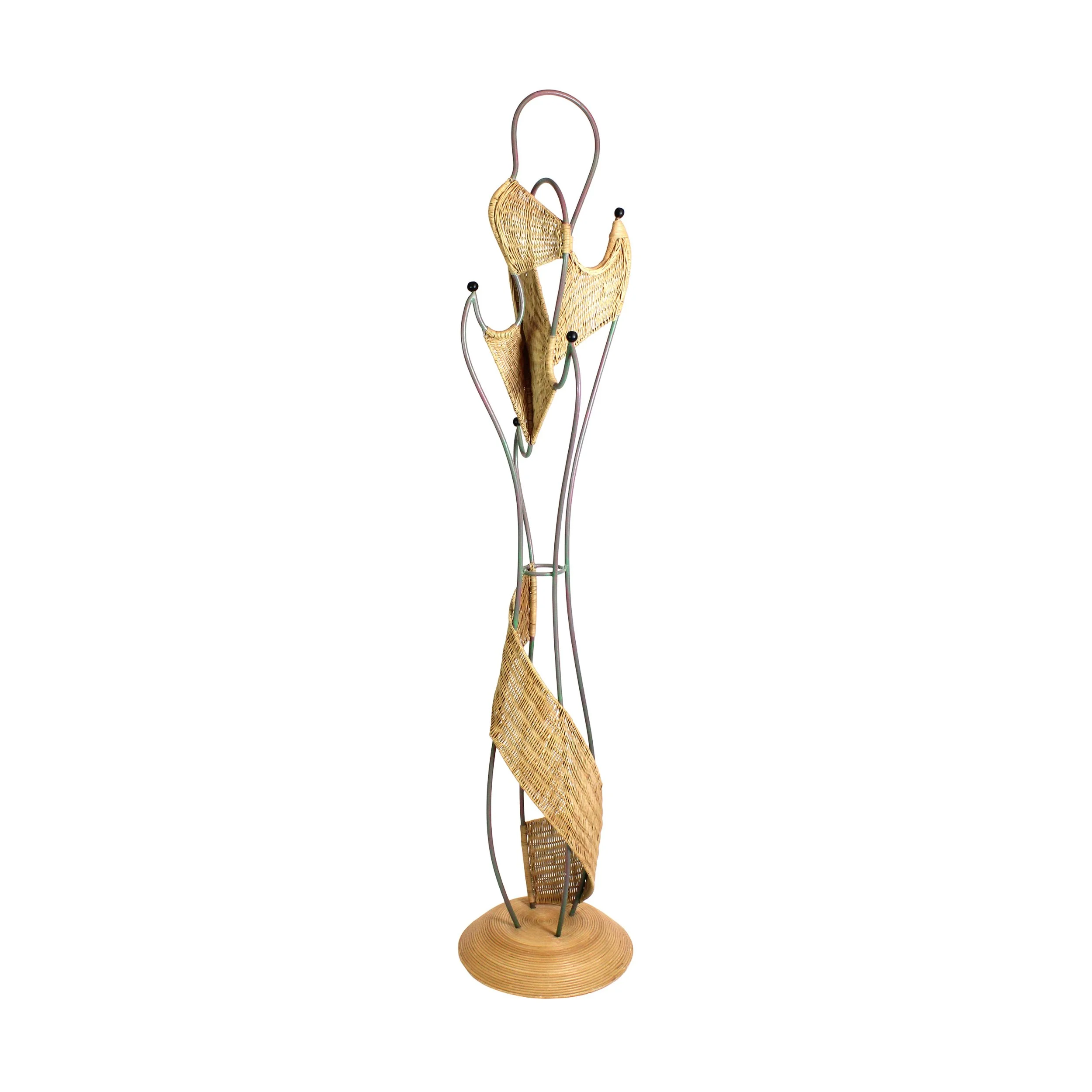 Tall and curvilinear coatrack with free flowing round metal structure with negative space between that has woven tan rattan in between some sections all on a wide round base