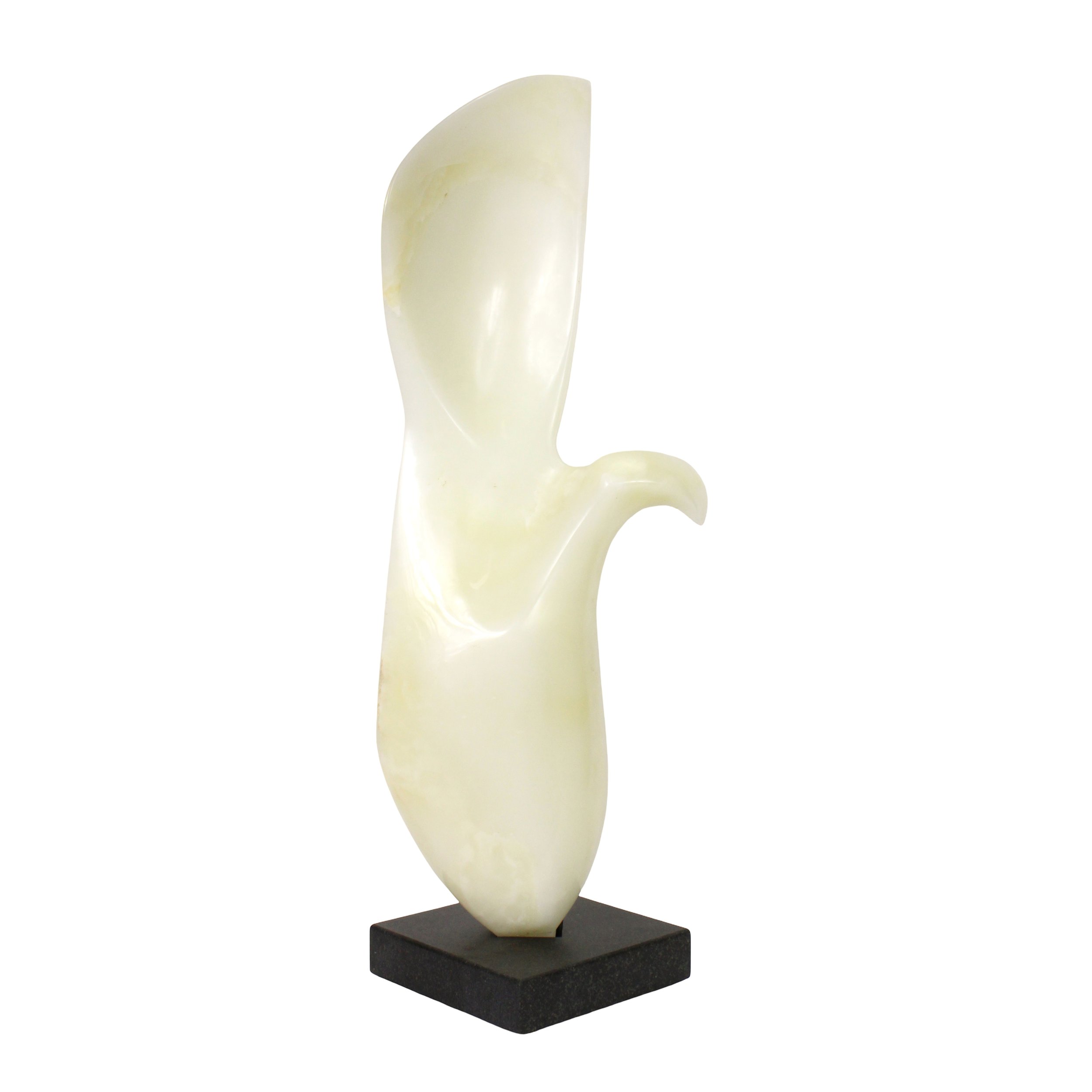 A white stone abstract sculpture on a black marble base. Wing shaped, the sculpture has a distinct concave section and a fin-shaped protrusion. The marble is pure white with no striations.