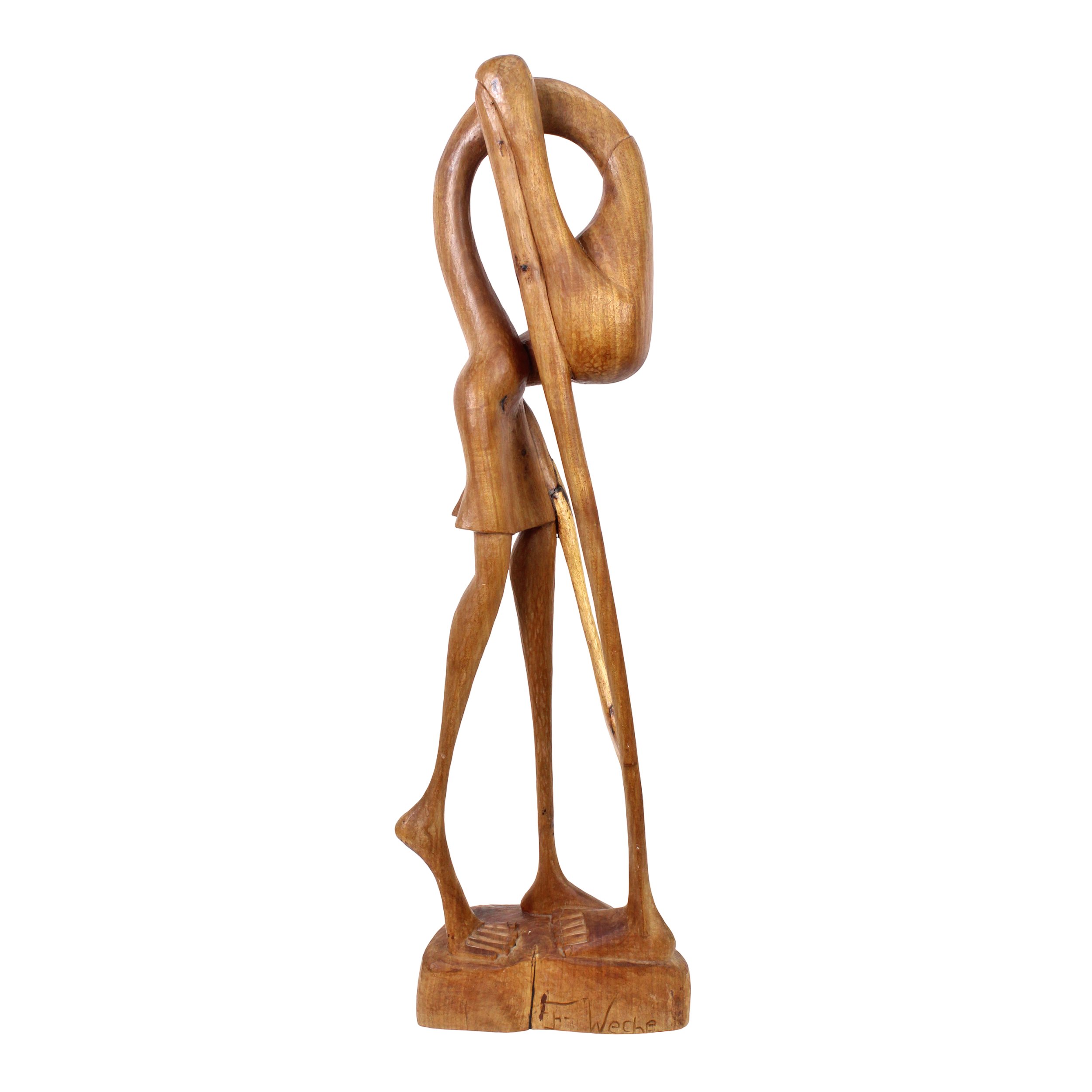 Smooth wood sculpture in an abstract shape. Top half resembles a pelican morphing to three human legs. A signature is visible at the bottom right. Warm wood tones and burls are present throughout.