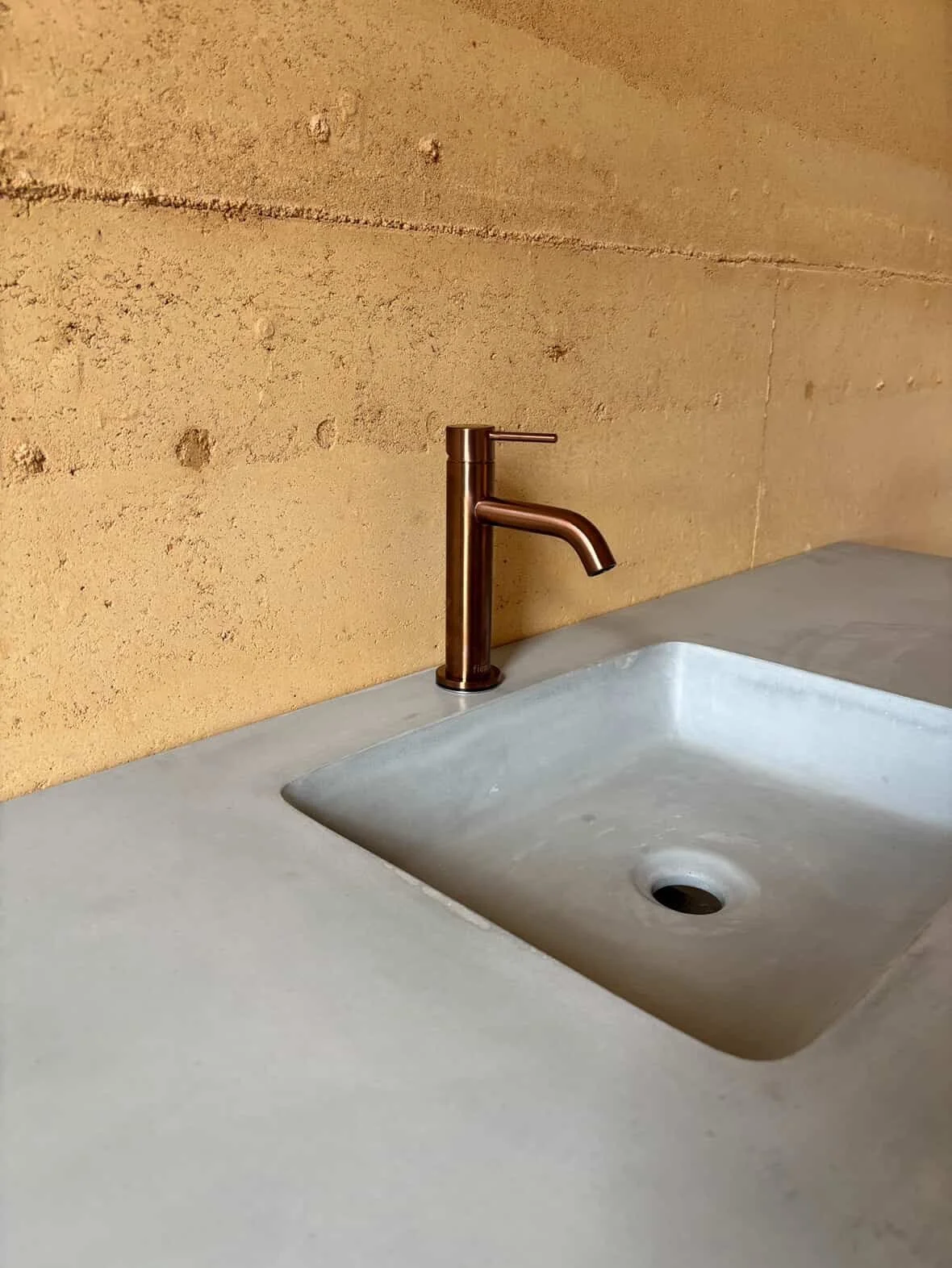 Rammed earth and concrete is just the perfect combo. The integrated vanity here is in our colour Blue Gum. 

@dir.tproject just low key building the house of the year.