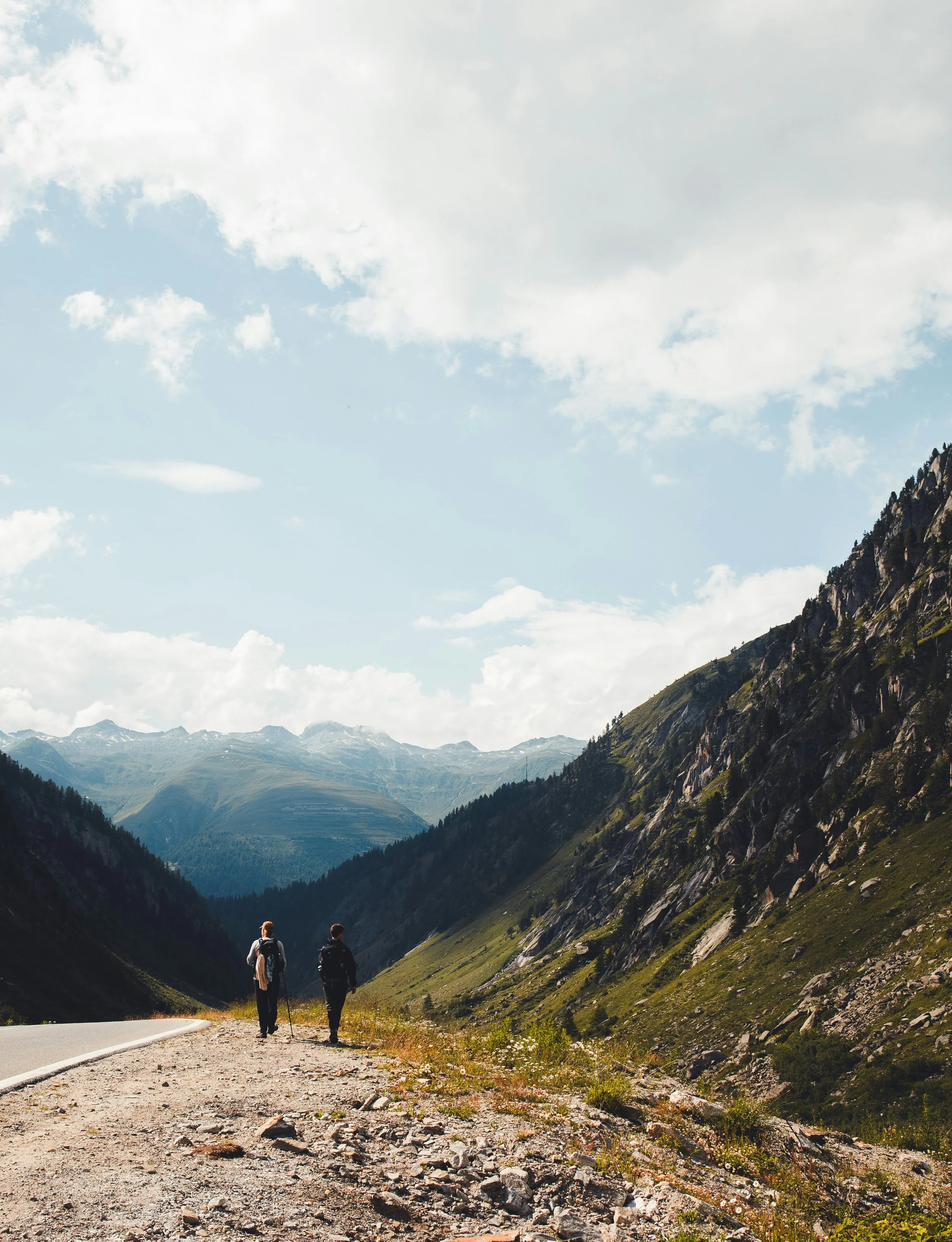Two people walking through and discovering a beautiful landscape of mountains and roads