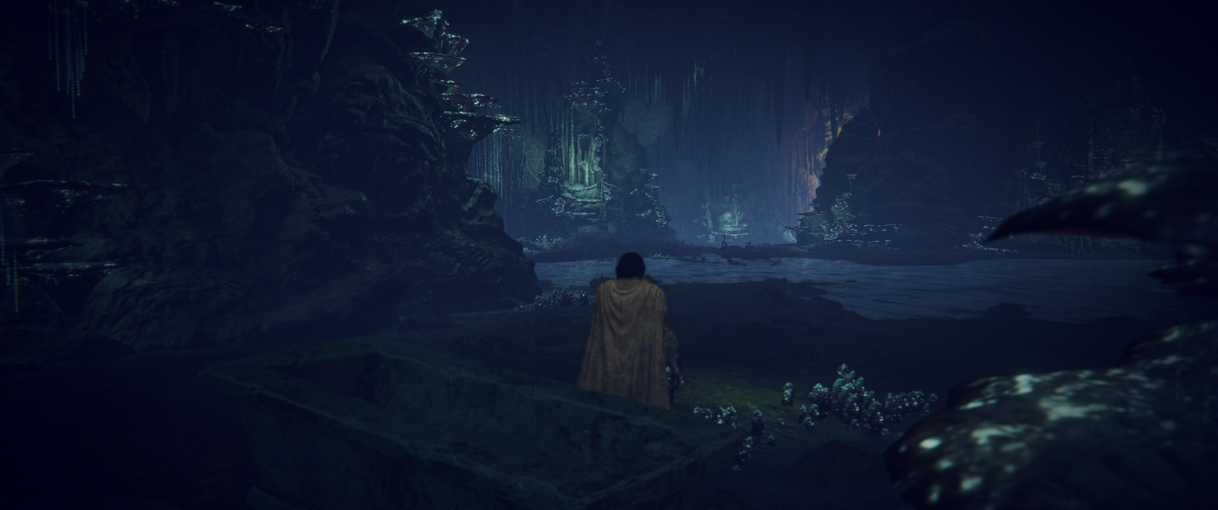 Ein Mensch in einem Umhang steht in einer dunklen, mystischen Höhle mit leuchtenden Felsen und Pflanzen, in der ein Wasserbecken sichtbar ist.