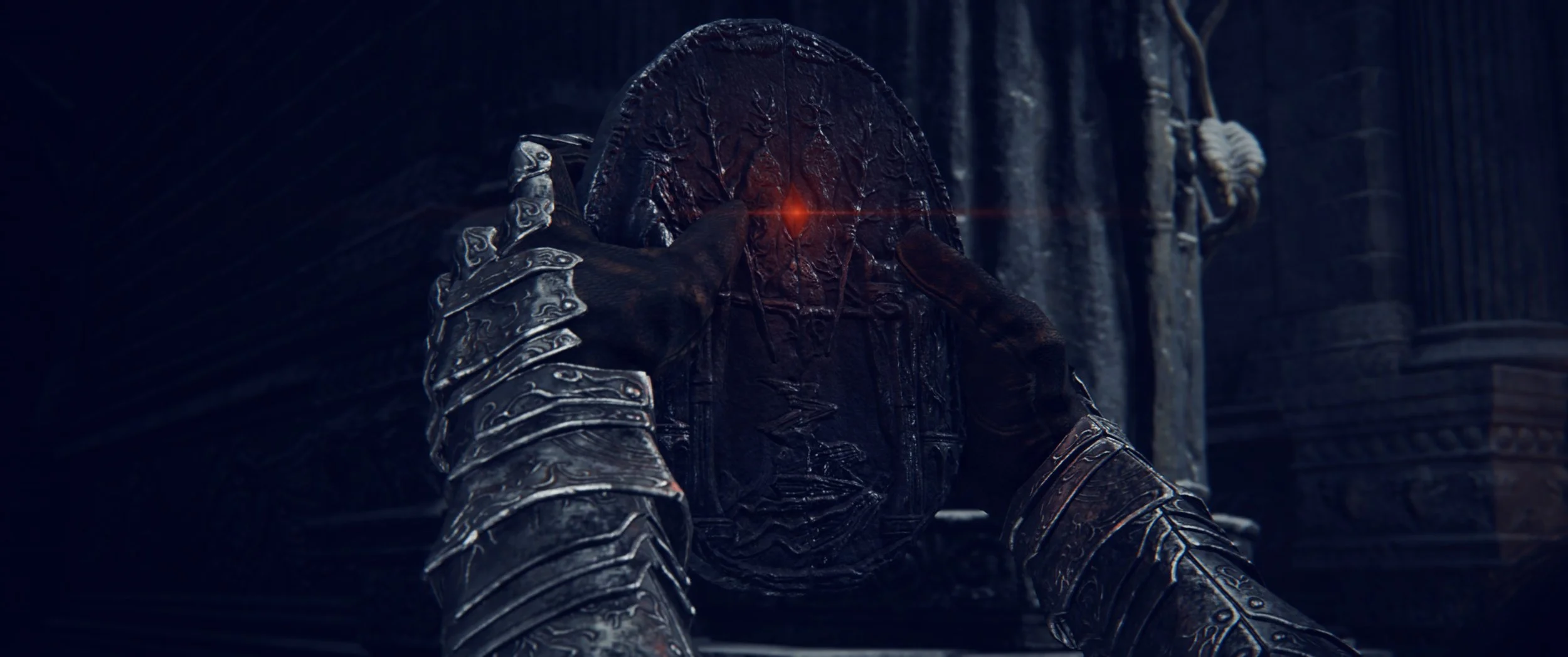 Ein dunkler, mysteriöser Charakter in einer schwarzen Rüstung mit einem verschlungenen Gesicht hält eine schwere, ornamentierte Waffe mit einer roten Lichtprojektion auf seine Stirn an einer mittelalterlichen, Ritter-ähnlichen Kulisse.