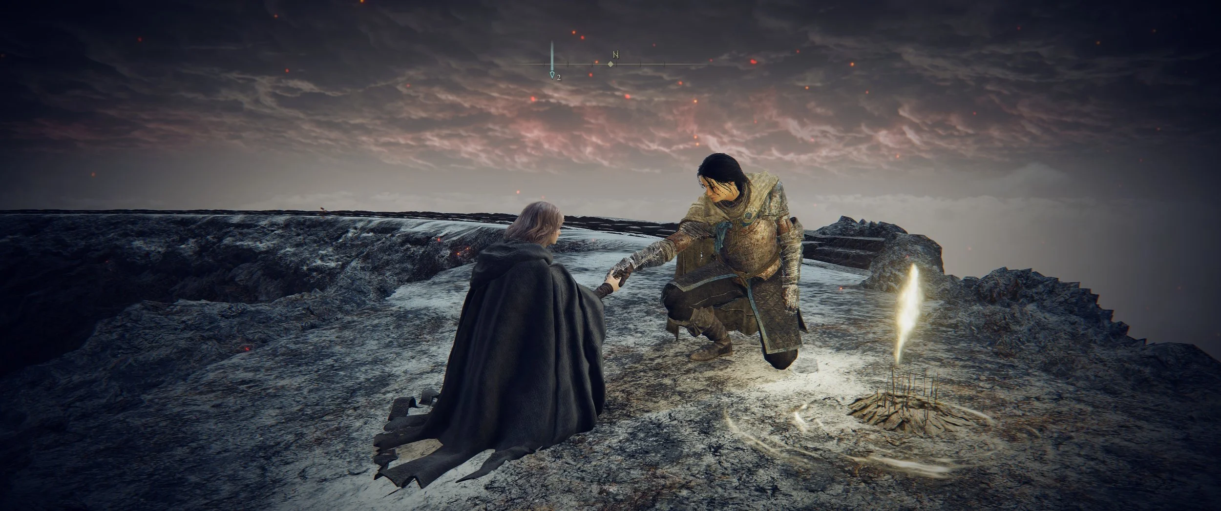 Zwei Menschen auf einer schwarzen, felsigen Oberfläche, eine Person kniet und die andere Person hilft ihr auf die Beine, im Hintergrund dunkler Himmel mit Wolken und roten Lichtern.