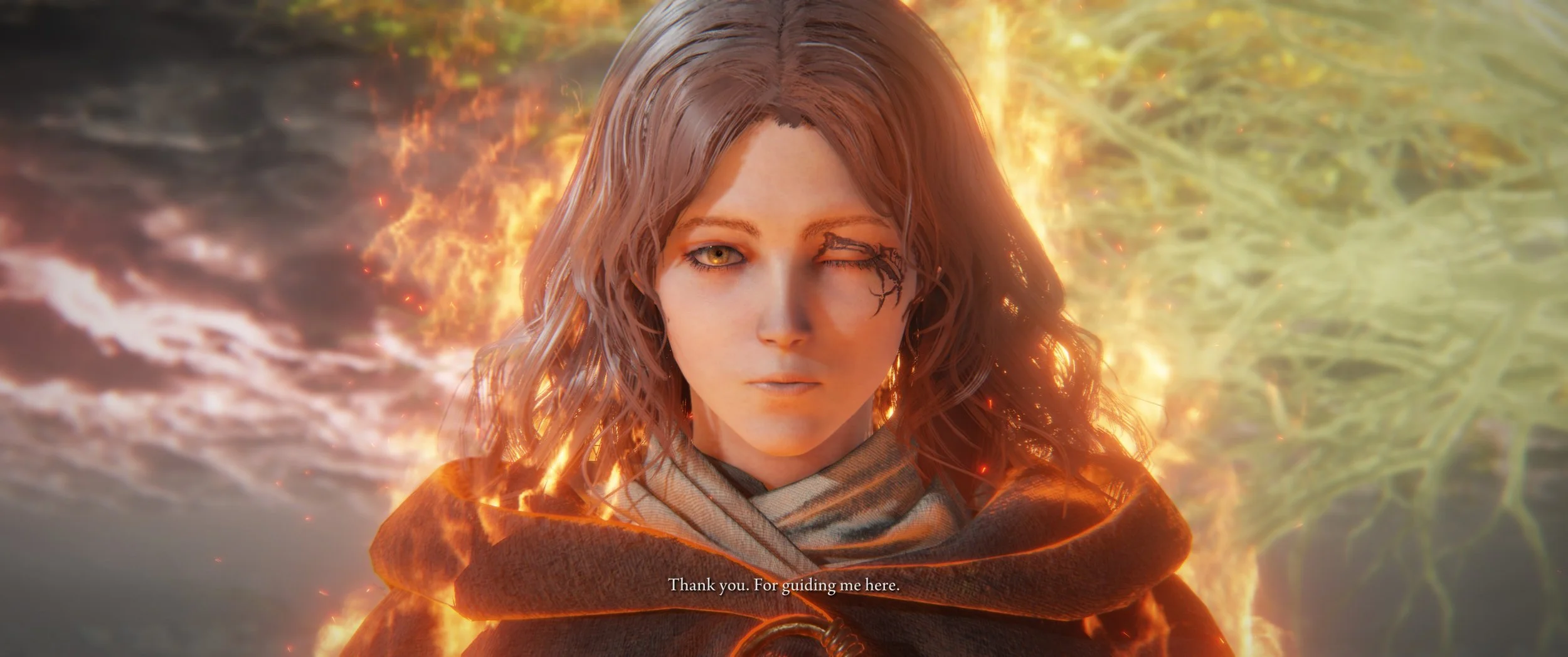 Eine junge Frau mit braunen, lockigen Haaren und einem verbrannten Auge steht vor einem Feuer und einer grünen Wasserfläche im Hintergrund. Sie trägt eine braune Robe und sagt: "Thank you. For guiding me here."