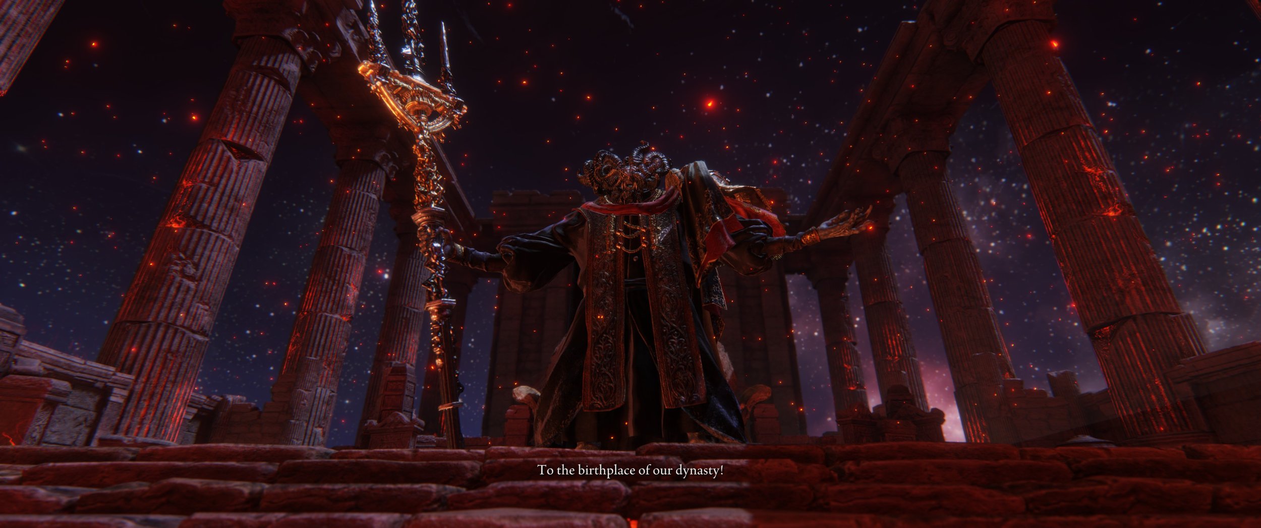 Eine mächtige Figur in einem prunkvollen Gewand steht vor antiken Säulen unter einem Sternenhimmel und hält einen leuchtenden Stab. Der Bildschirm zeigt einen Untertitel: 'Zur Geburtsstätte unserer Dynastie!'.