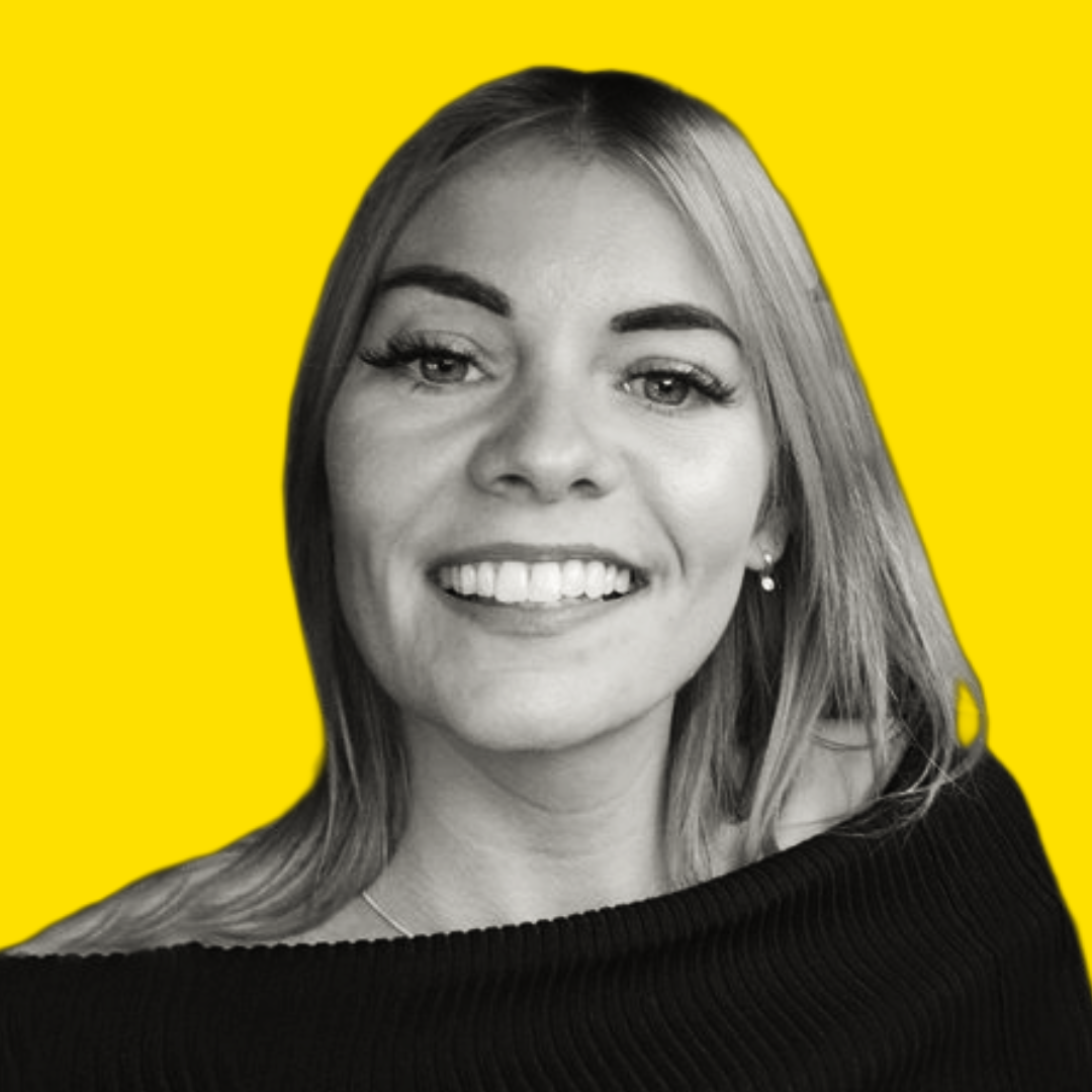 Black and white portrait of a smiling woman with shoulder-length hair, wearing a black top, against a bright yellow background.