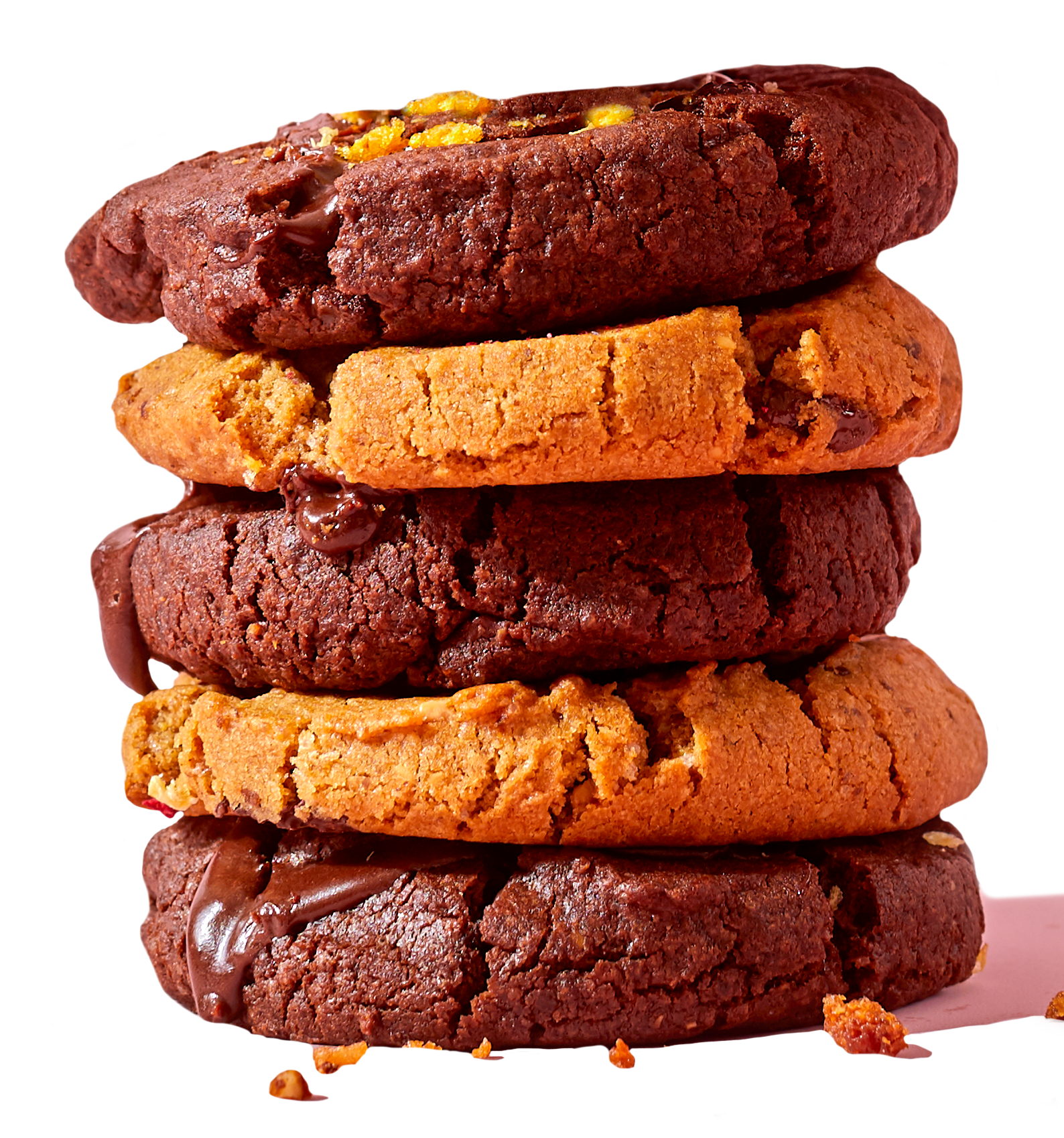 Stacked cookies of various types, including chocolate chip, double chocolate, and oatmeal, with some showing melted chocolate.