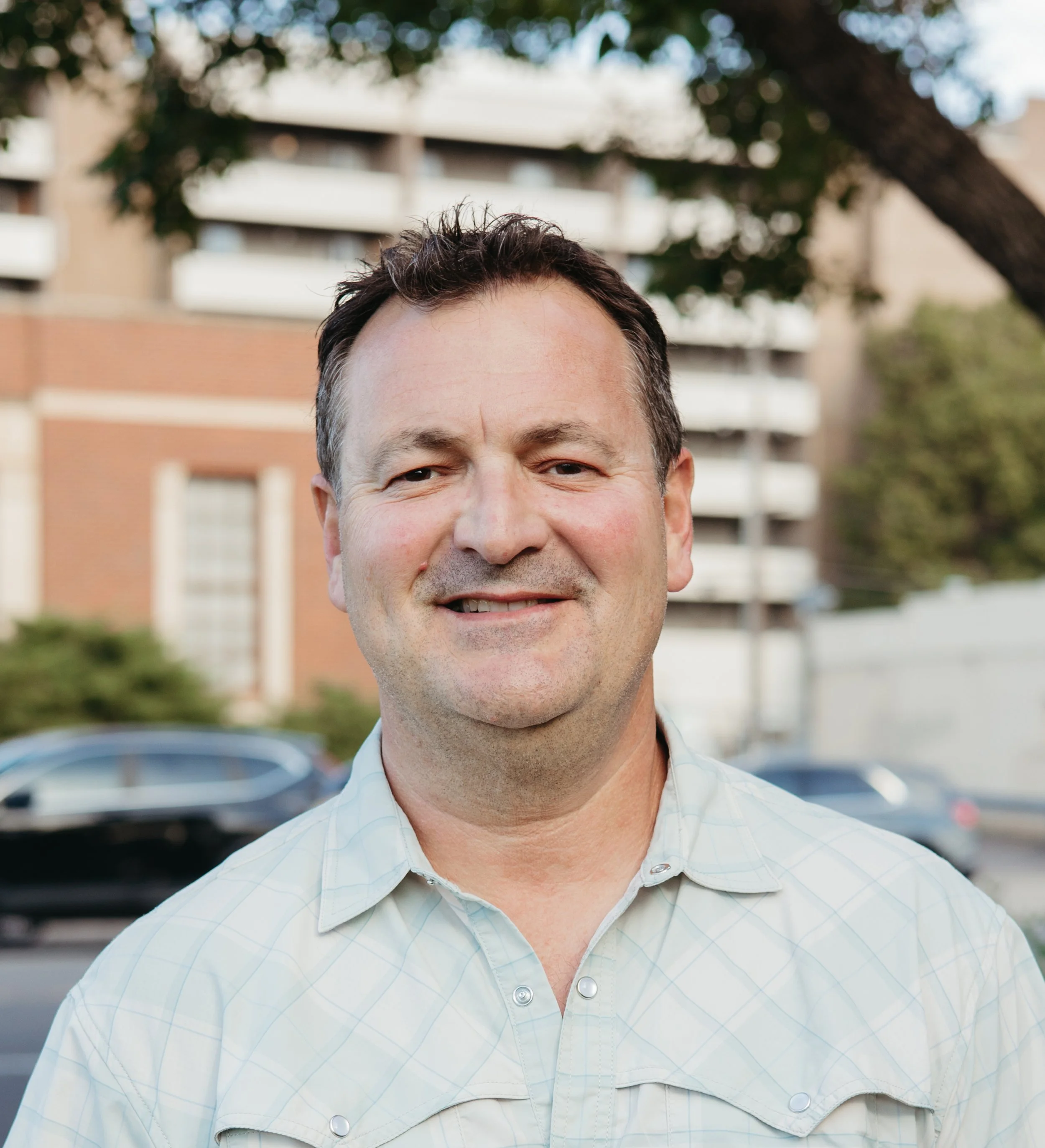 Headshot of George Gastis smiling at the camera outside CAFE 180