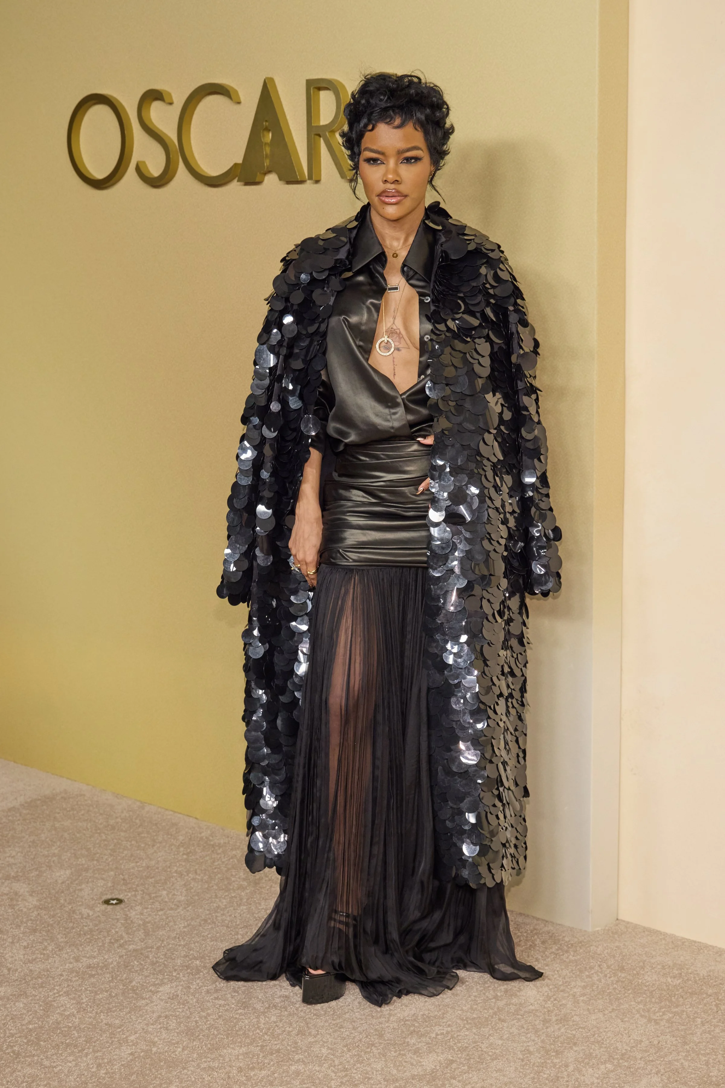 Teyana Taylor in a sheer black Cong Tri shirt dress and sequined Altuzarra coat at the 98th Oscars Luncheon.