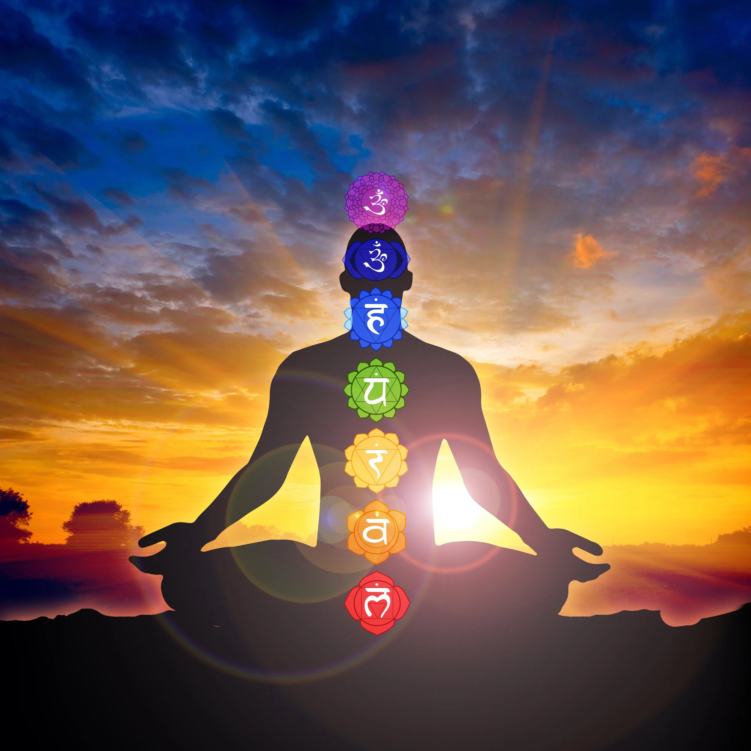 Silhouette of a person meditating with chakras aligned against a sunset background.
