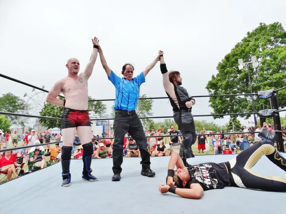 Winners and referee raising hands