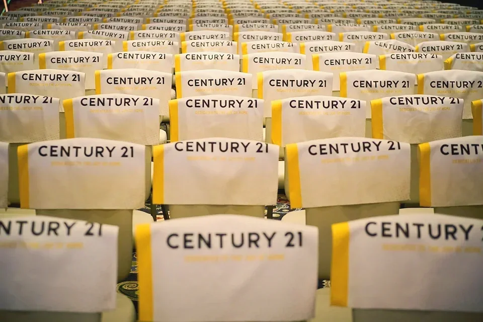 Rows of chairs with white covers and yellow CENTURY 21 accents

corporate event photography Las Vegas Bellagio Conference Center