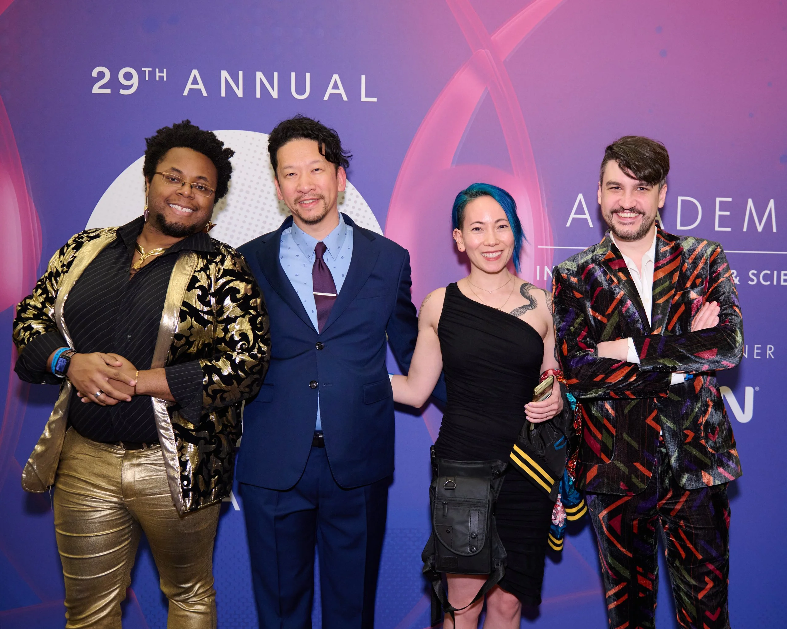 Four diverse people posing at the 29th Annual Academic Conference, standing in front of a purple backdrop with event branding.