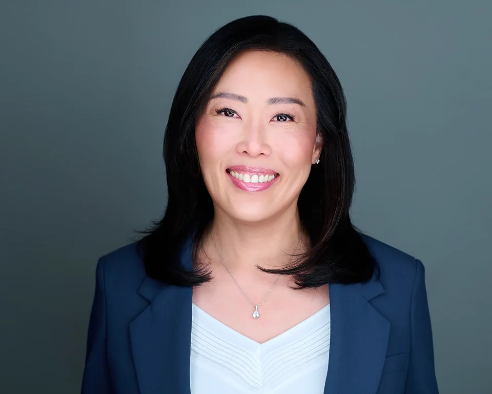Headshot of Asian woman dressed professionally on a gray background. image shot at Las vegas Studio