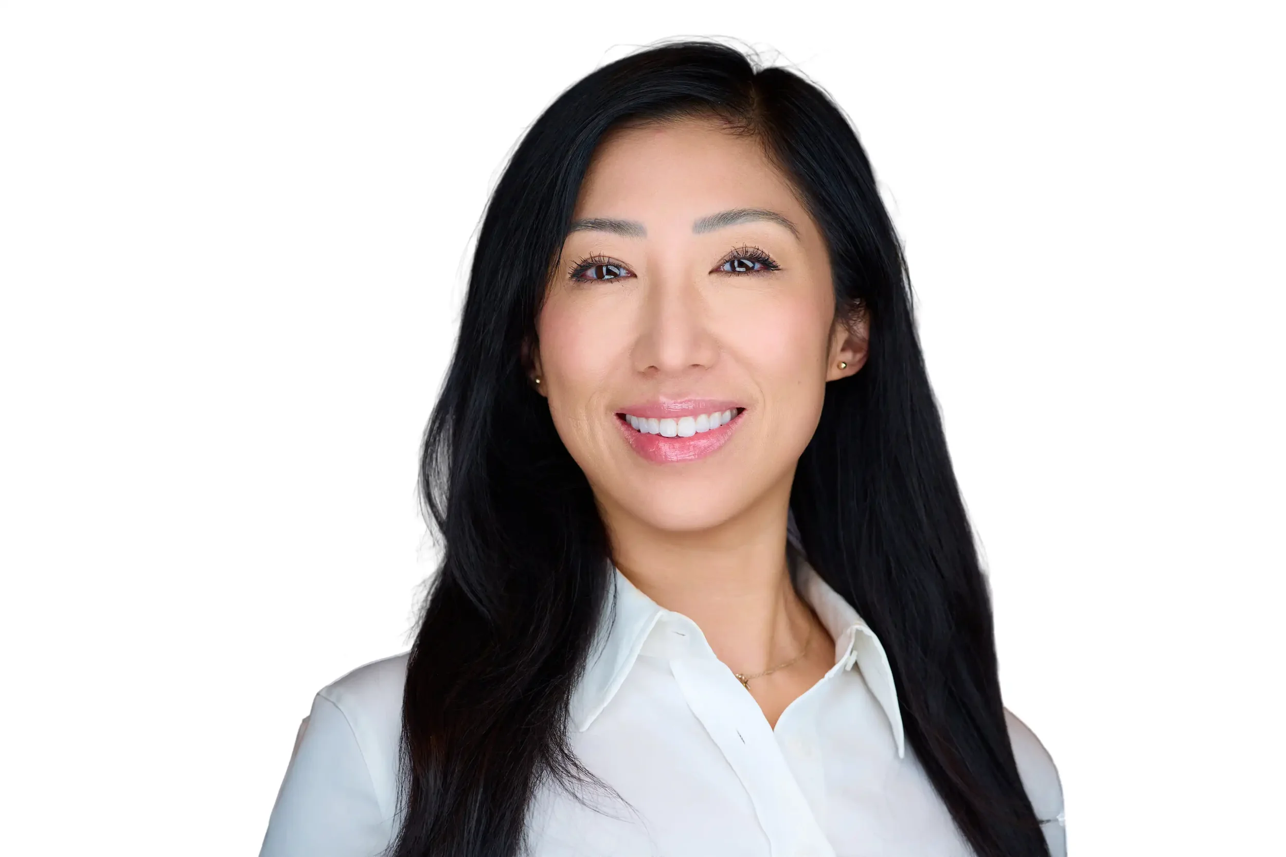 Portrait of a smiling woman with long black hair wearing a white collared shirt against a white background.