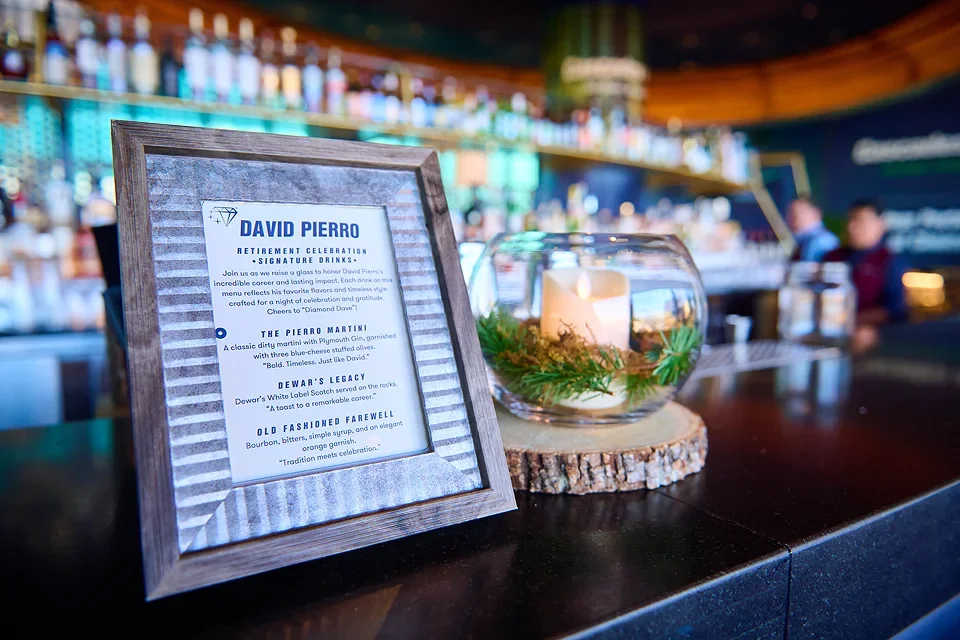 Menu and candle on a bar counter celebrating a retirement event.