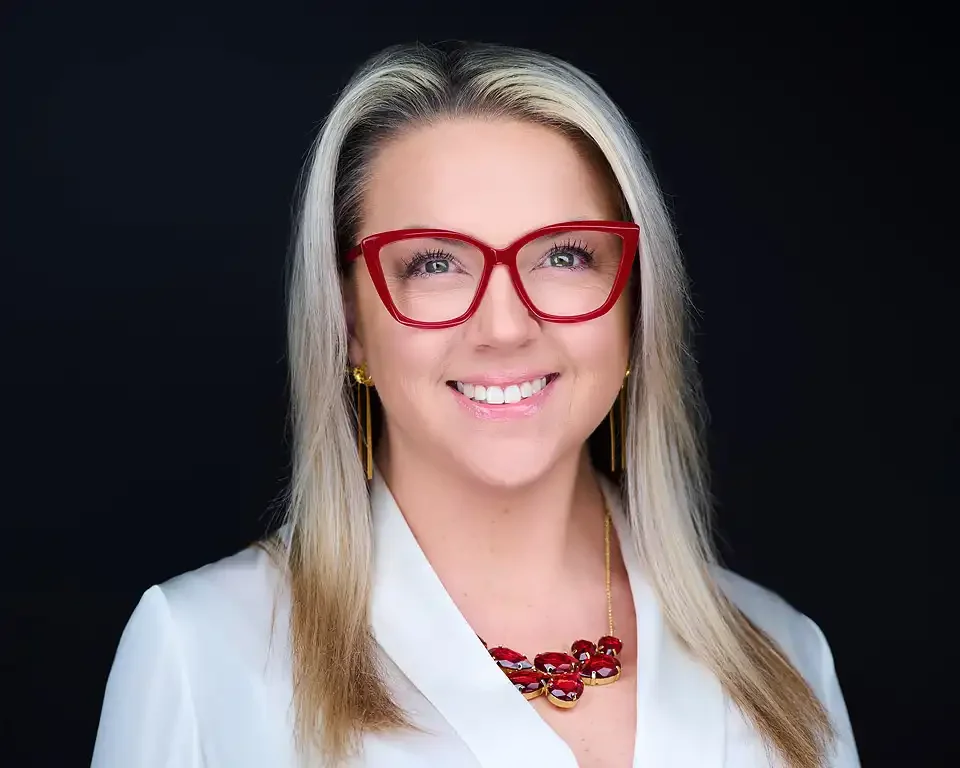 Professional headshot of Author Kristin Reinbold, woman with blonde hair wearing a white blazer and red necklace, studio session by Pandorica Headshot Studio Las Vegas