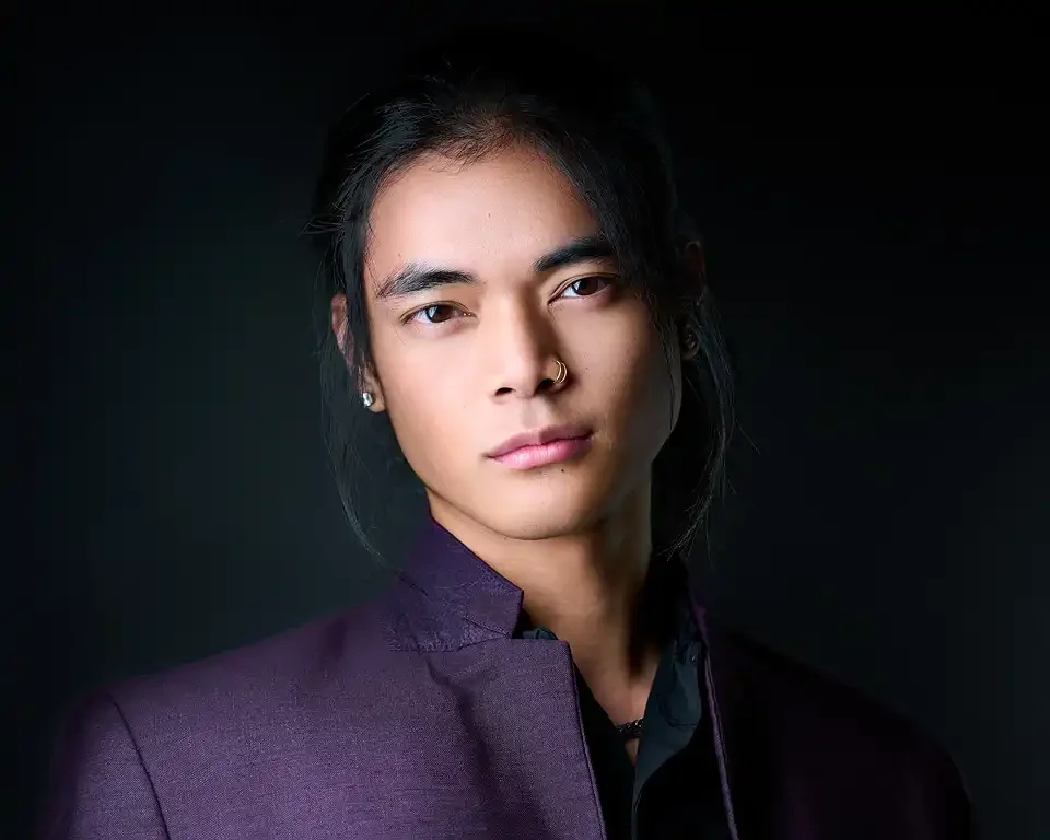 Professional headshot of a man with dark hair wearing a purple blazer, studio session by Pandorica Headshot Studio Las Vegas
