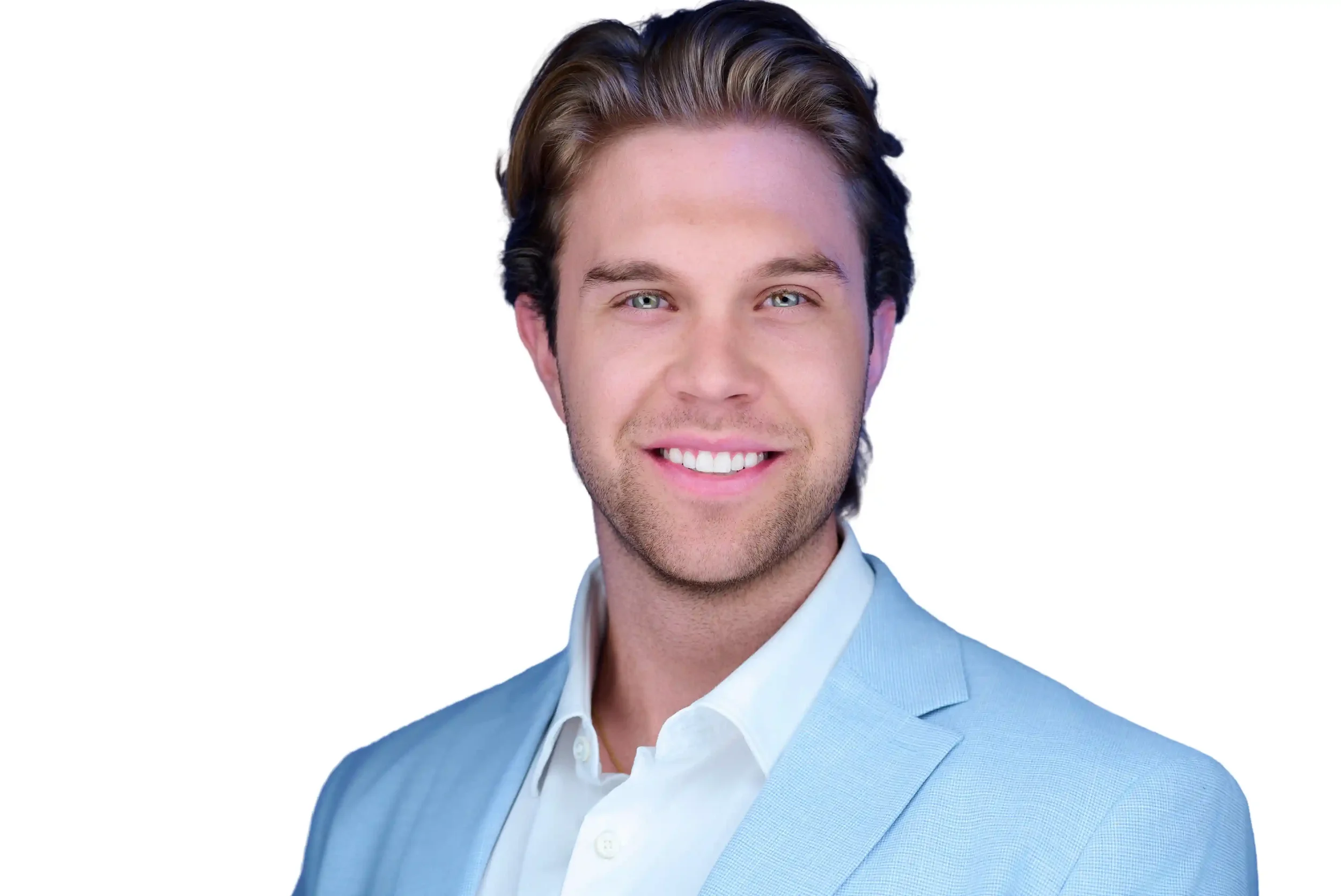 A young man with short brown hair, blue eyes, and a light beard, smiling while wearing a light blue blazer and white shirt, in front of a plain white background.