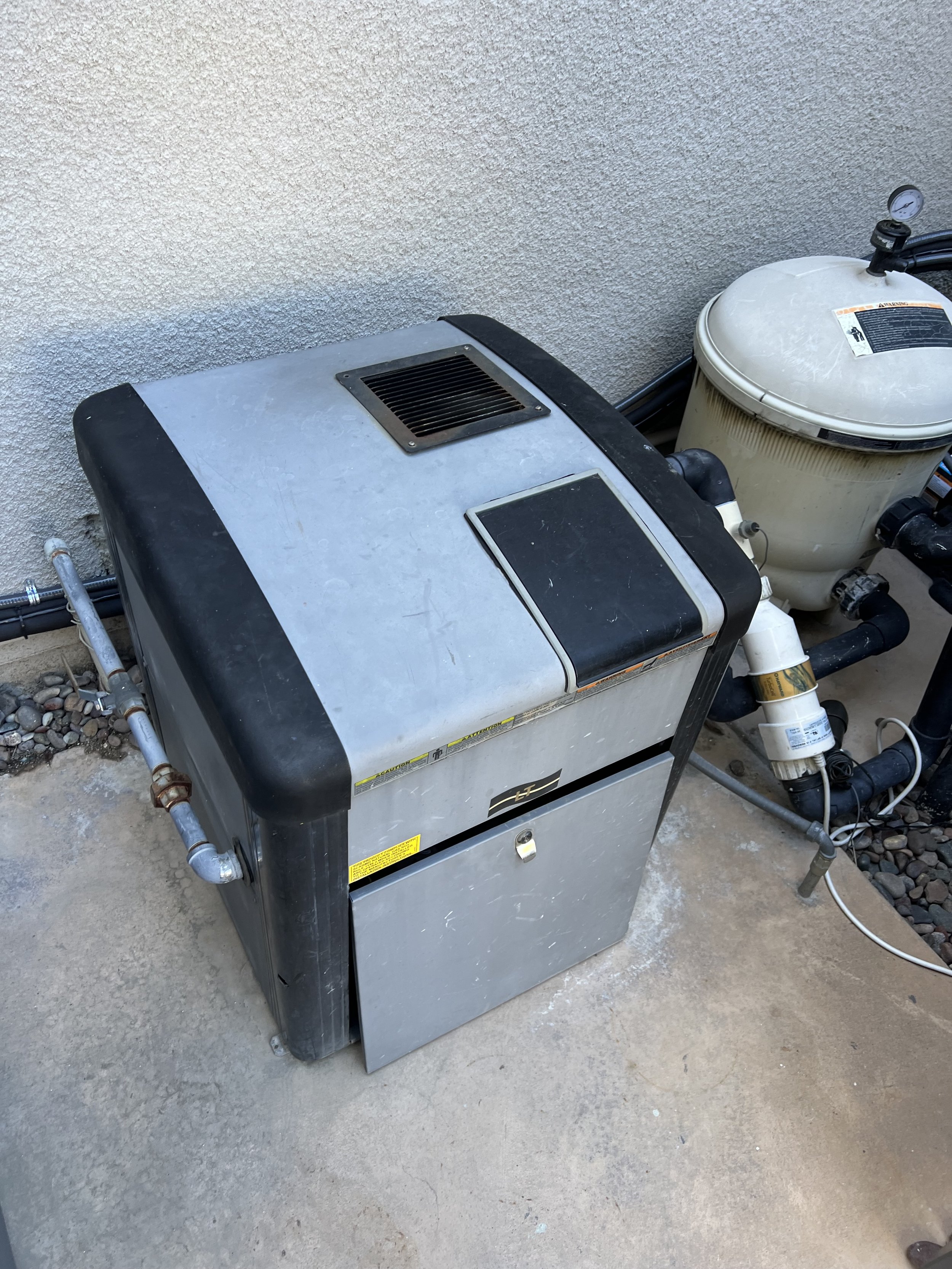 Outdoor pool heater and filter system on concrete pad