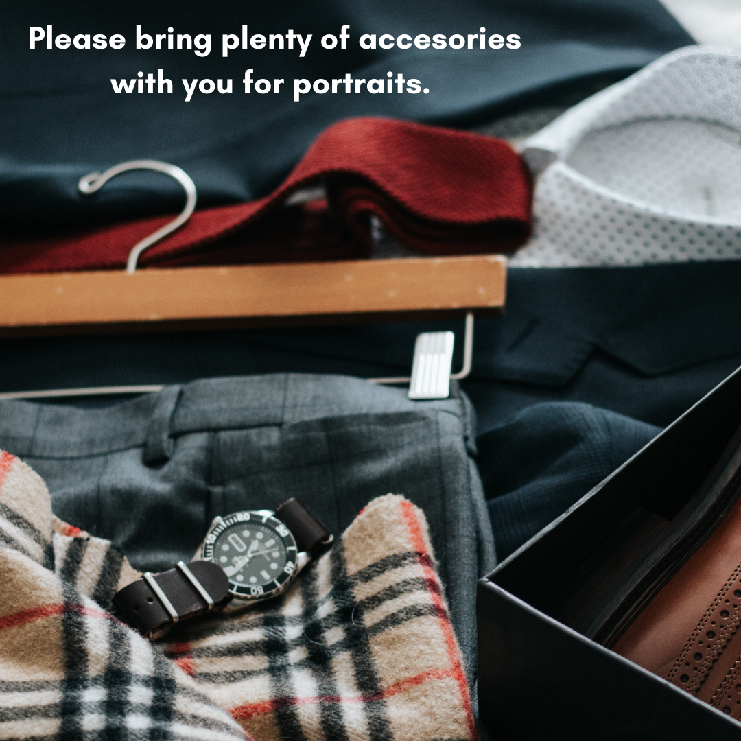 A collection of men's clothing and accessories, including a watch, a plaid scarf, dress pants, a hanger with a coat, and a box with shoes, on a bed with a message about bringing accessories for portraits.