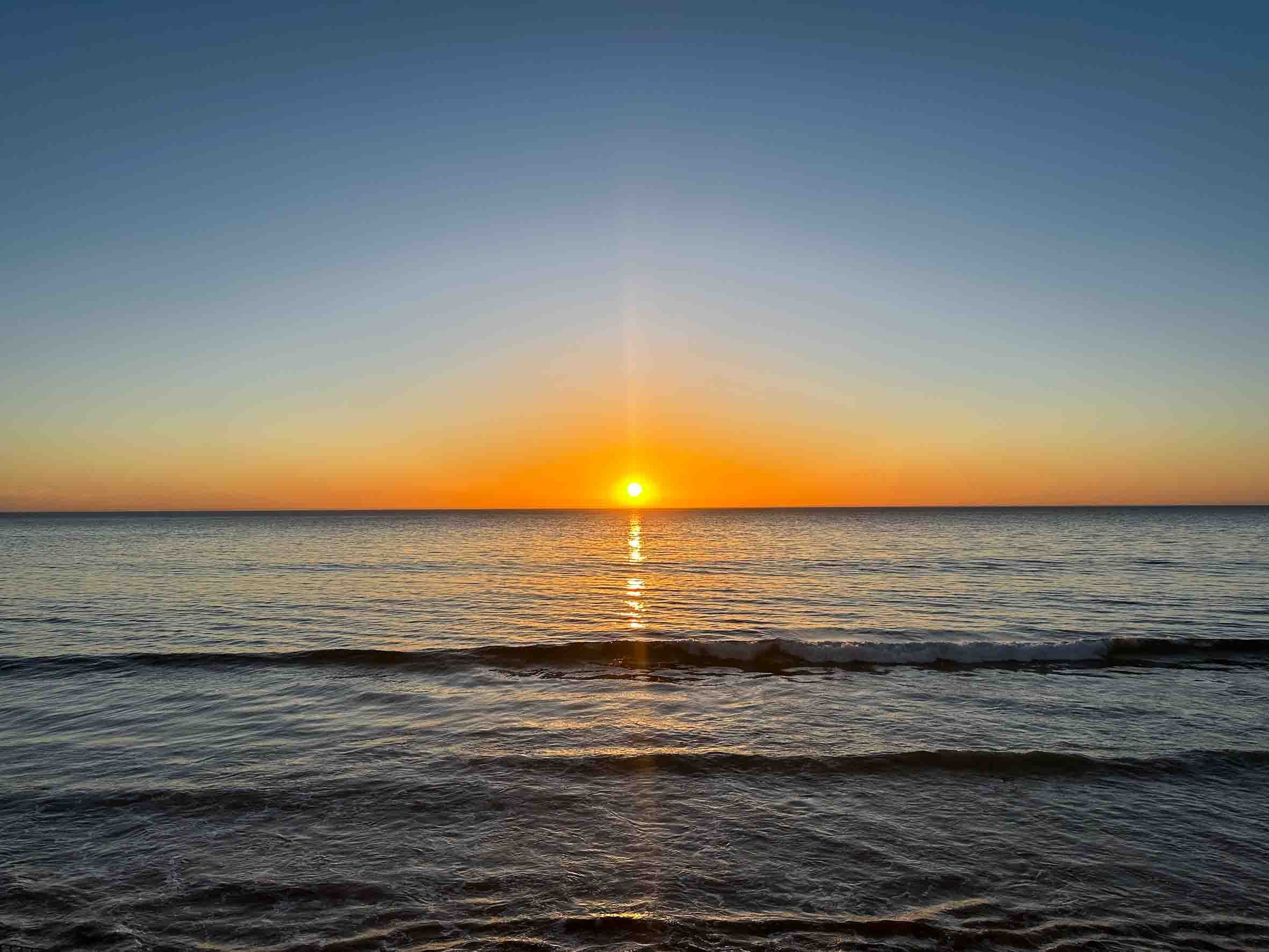 Sunset over calm ocean waves
