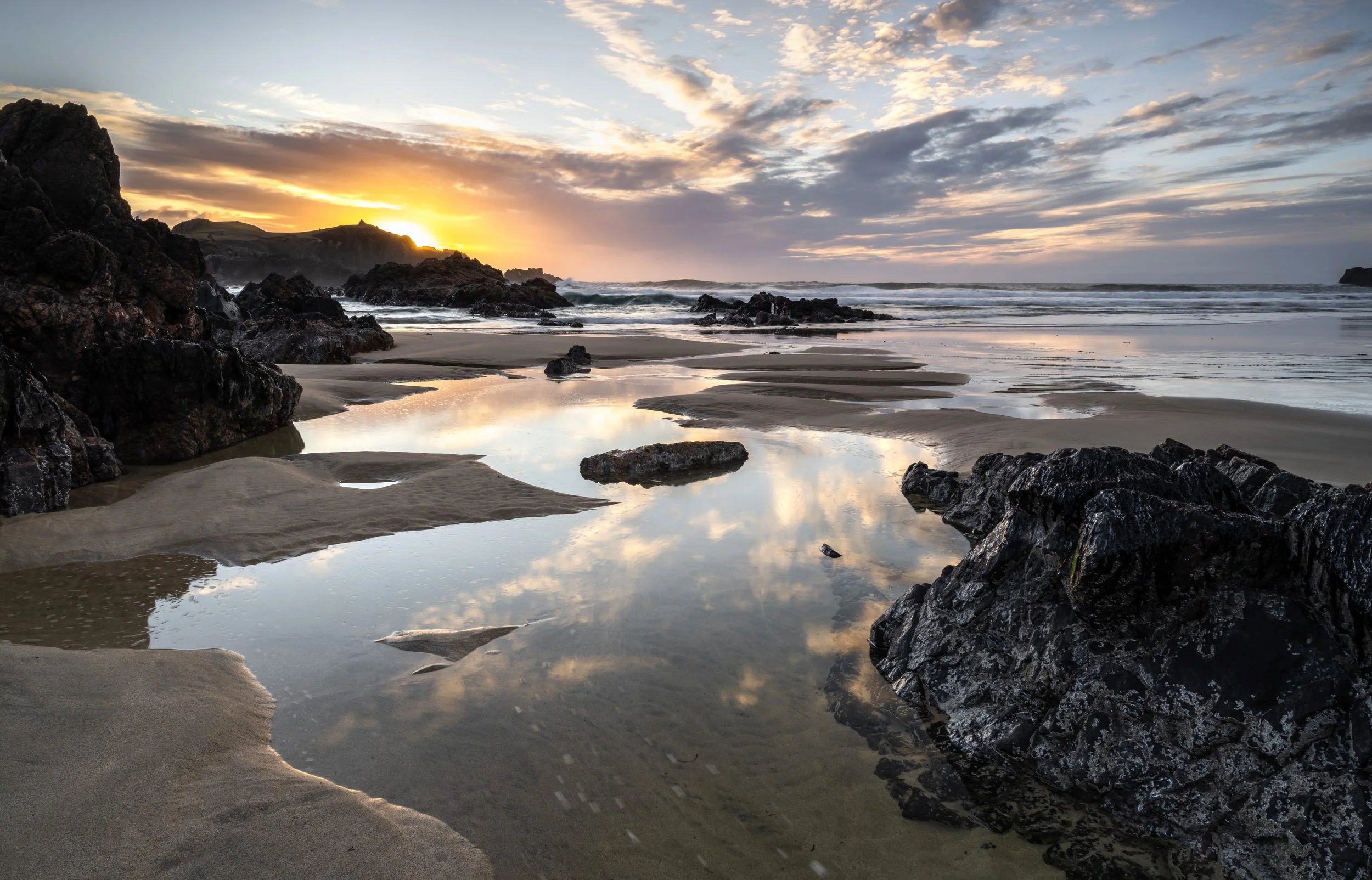 Soft evening light moving across Mangersta Beach on the Isle of Lewis, catching wet sand and gentle surf as colour shifts through the scene, from the fine art print “Mangersta Beach.”