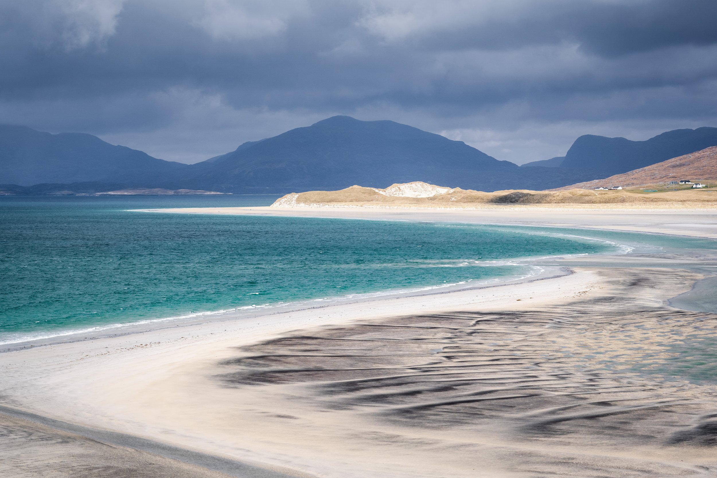 View over Seilebost on the Isle of Harris, with pale sands curving around the bay, turquoise water shifting with the light and the Harris hills rising beyond, from the fine art print “Seilebost View.”