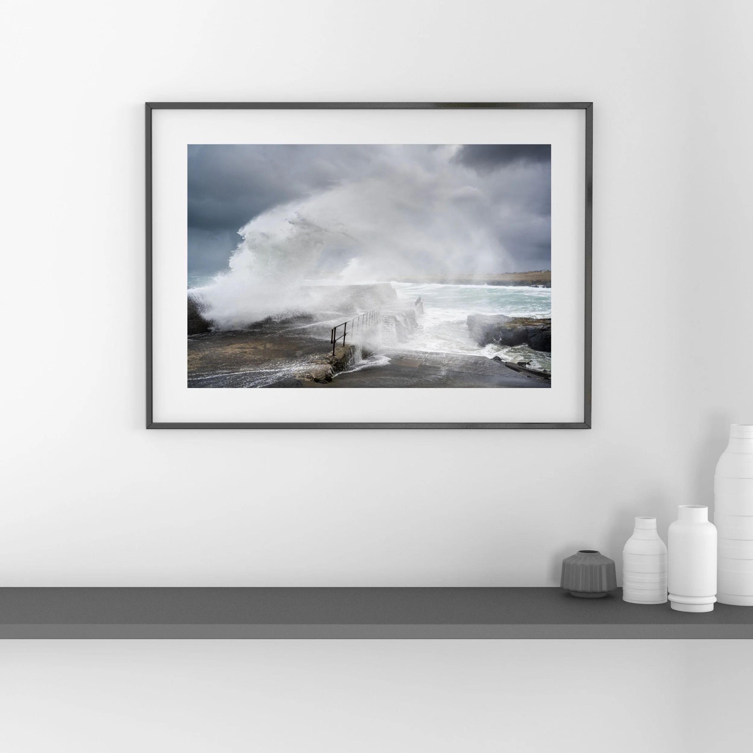 Framed fine‑art print of an Atlantic storm wave at Port of Ness, shown hanging on a wall.