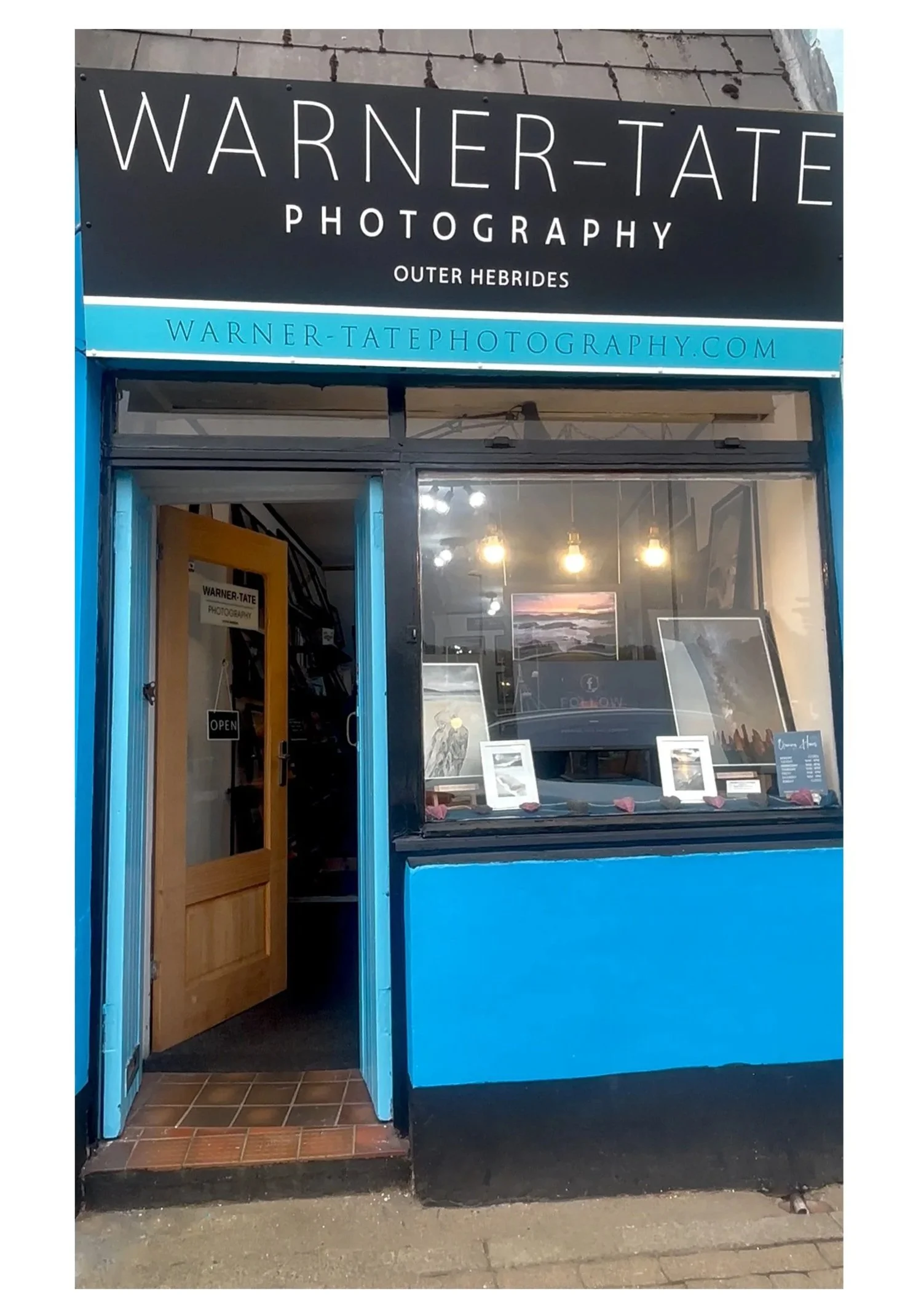 Warner‑Tate Photography gallery in Stornoway, Isle of Lewis, with black and blue signage and framed Outer Hebrides prints in the window.