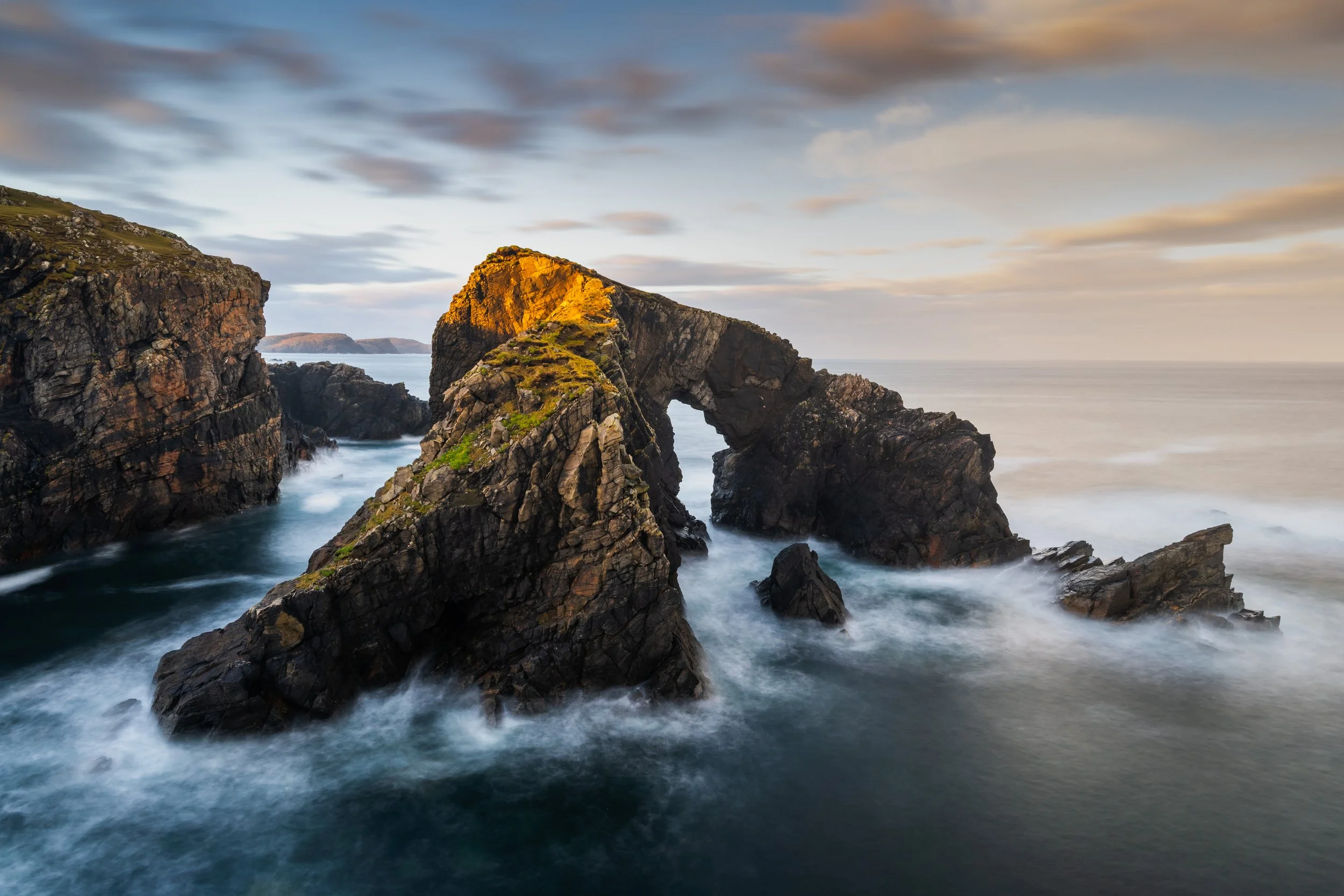 Stac A'Phris Sea Arch Isle of Lewis Outer Hebrides Seascape photography long exposure photography at sunrise with textured sea around the base golden light catching the top of the sea arch creating some nice light