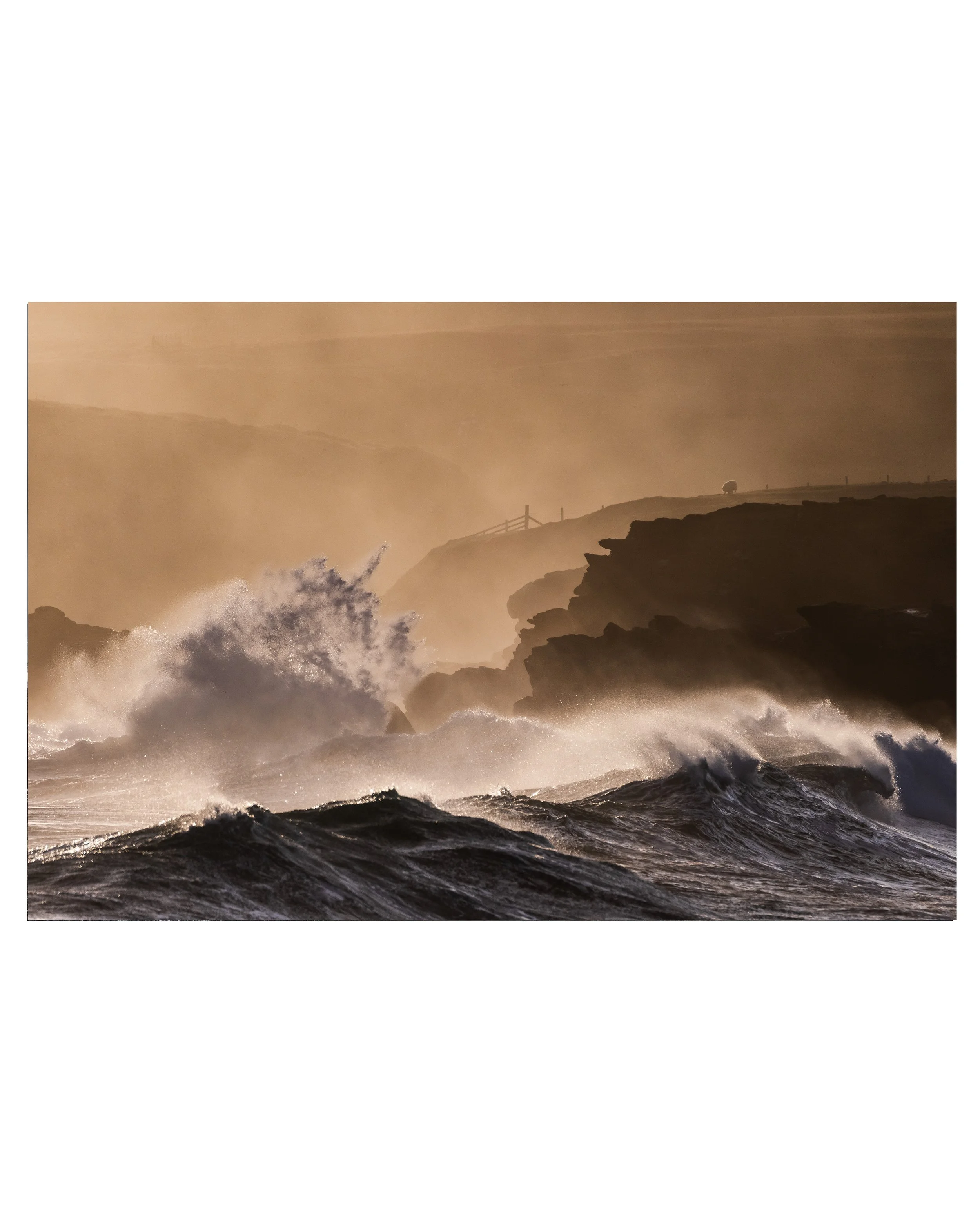 Port of Ness at sunrise on the Isle of Lewis, with towering Atlantic waves crashing into the rocks under warm morning colour.