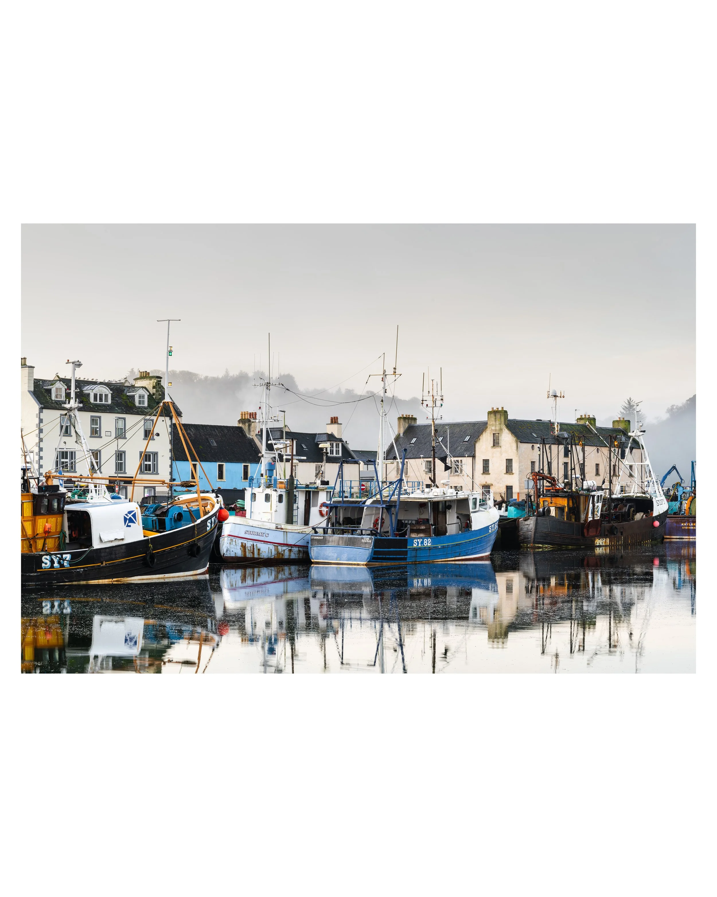Stornoway Harbour photography print showing fishing boats in calm winter light, with soft mist and reflections across the still water.