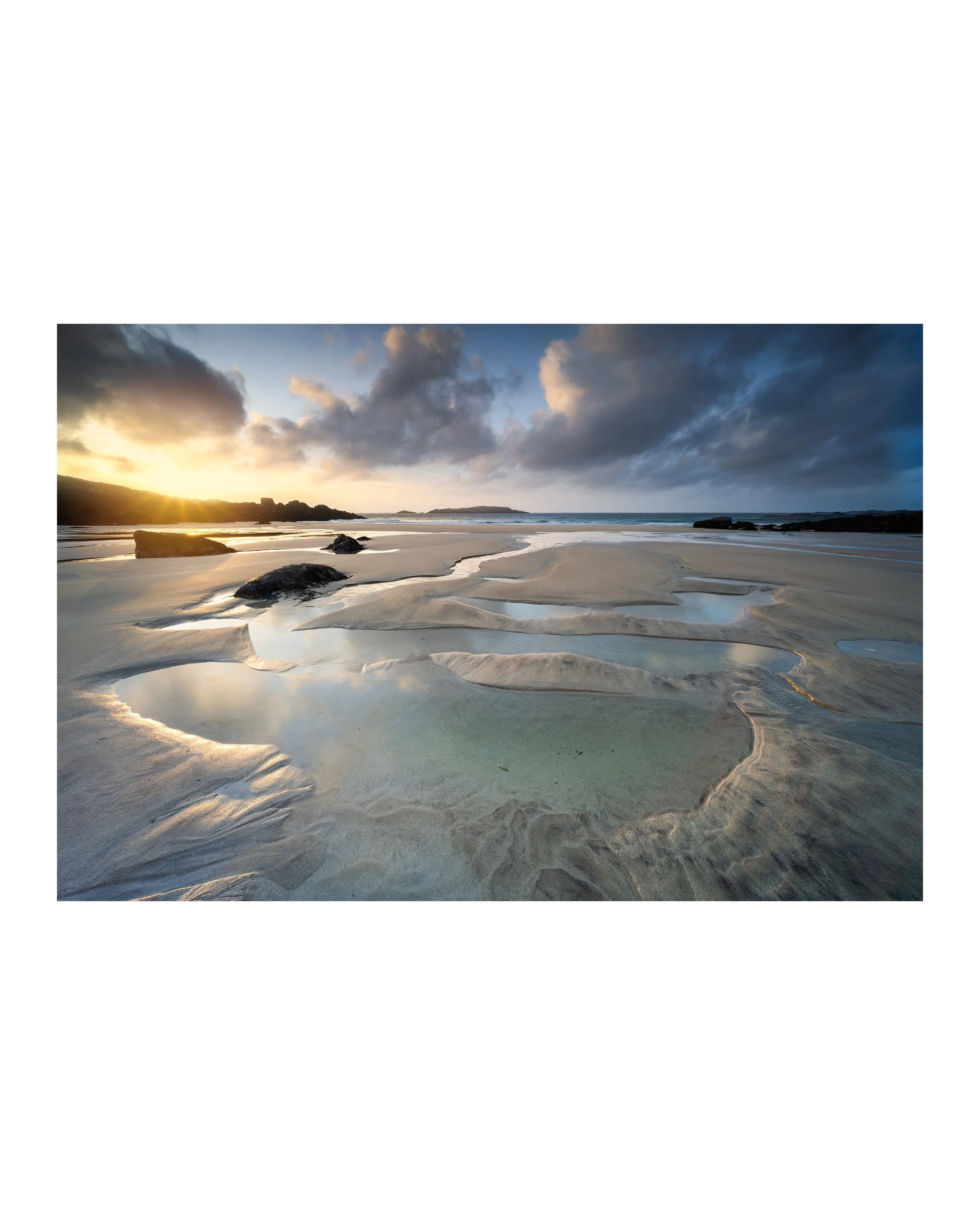 Fine‑art print showing evening light across the sand and rock pools at Mealasta Beach in Uig on the Isle of Lewis.
