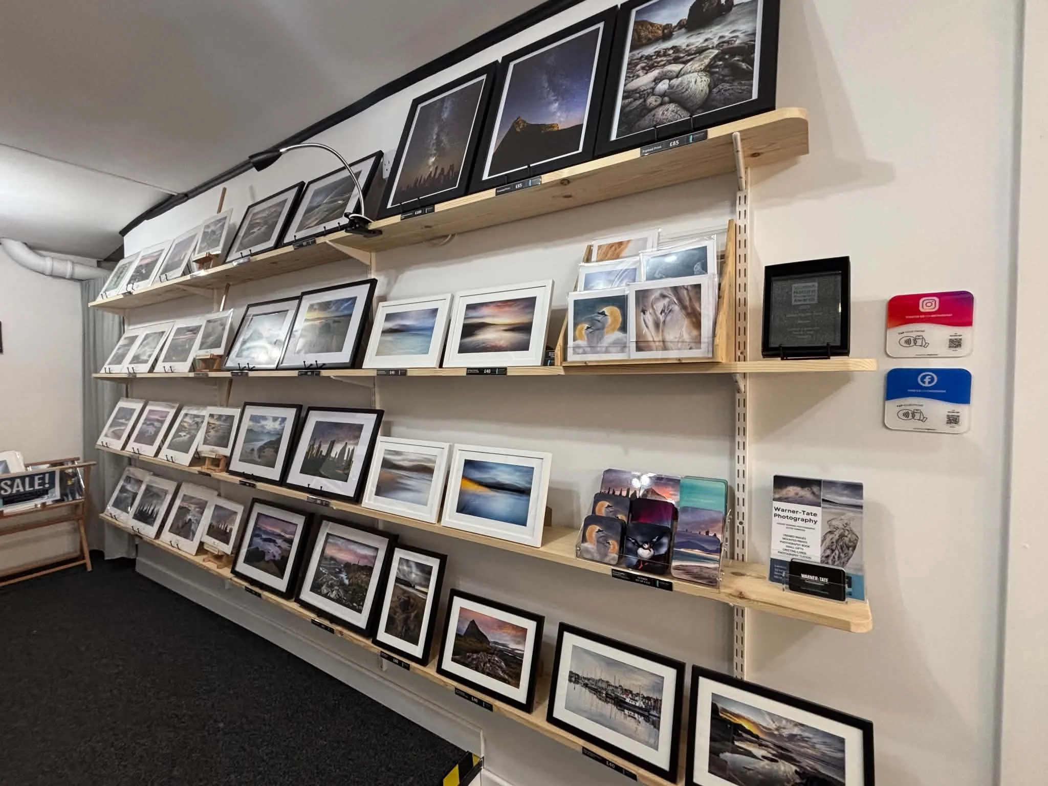 Mounted prints and island‑inspired gifts displayed inside Warner‑Tate Photography Gallery in Stornoway.