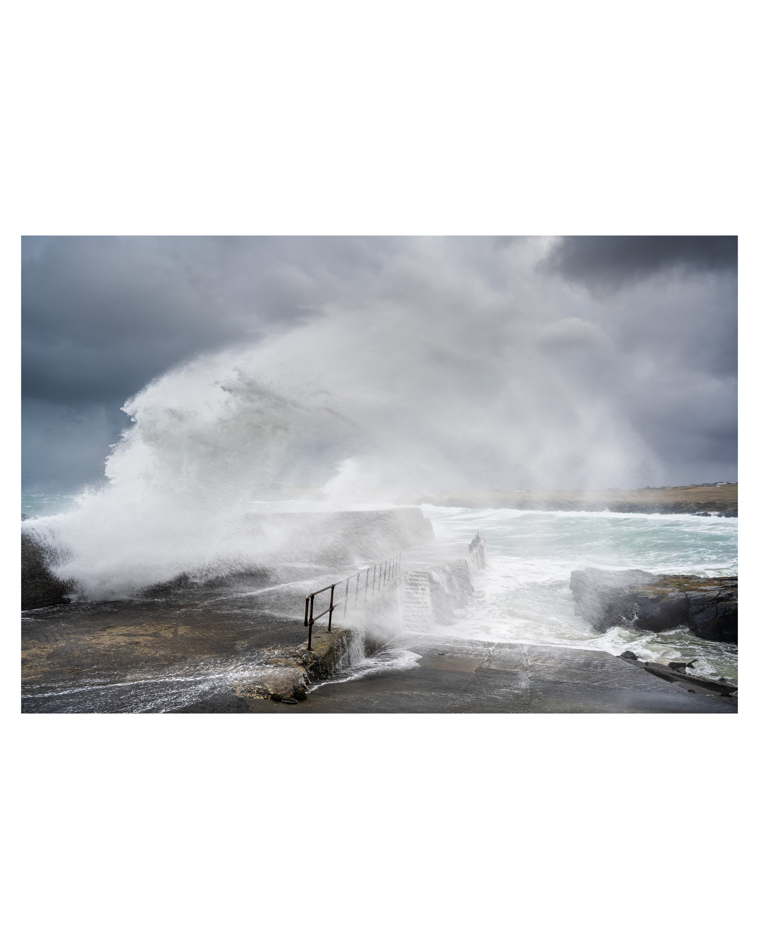 Fine‑art seascape photograph of wild Atlantic waves lifting against the harbour wall at Port of Ness.